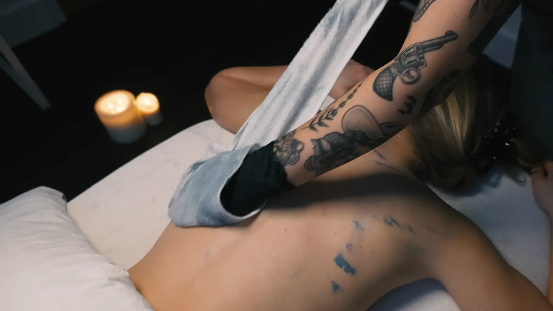 removing a charcoal bamboo treatment from the back afterthe facial, with the towel being gentle