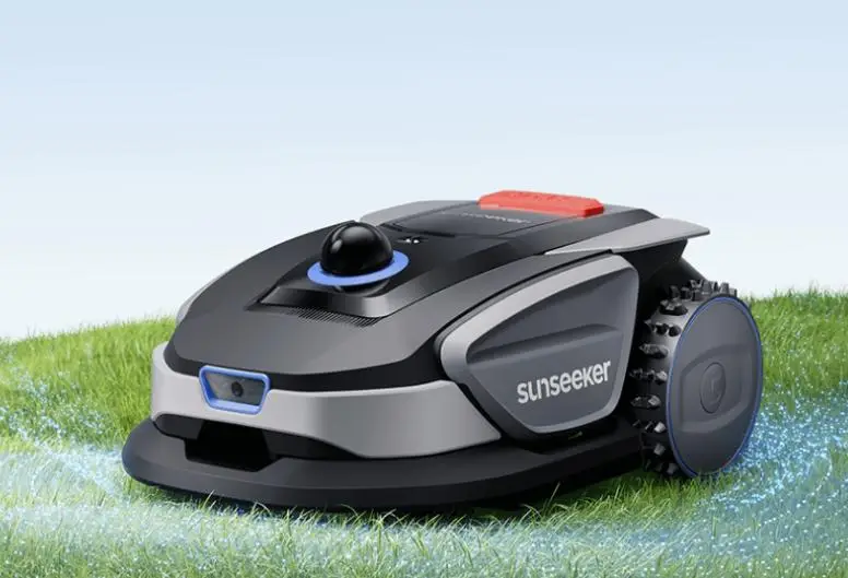 Robotic lawn mower on green grass under clear blue sky