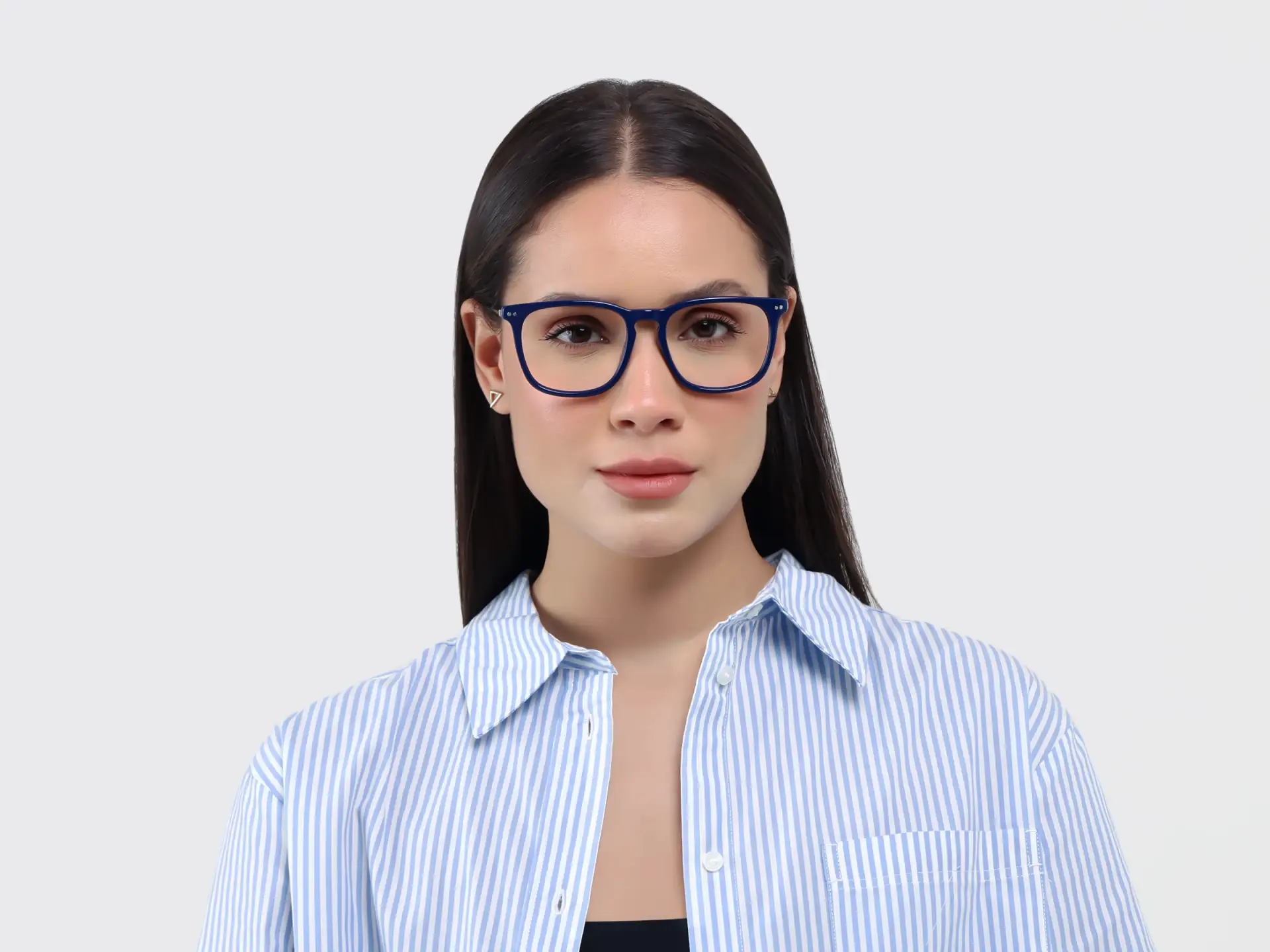 Woman wearing blue eyeglasses and striped shirt against plain background