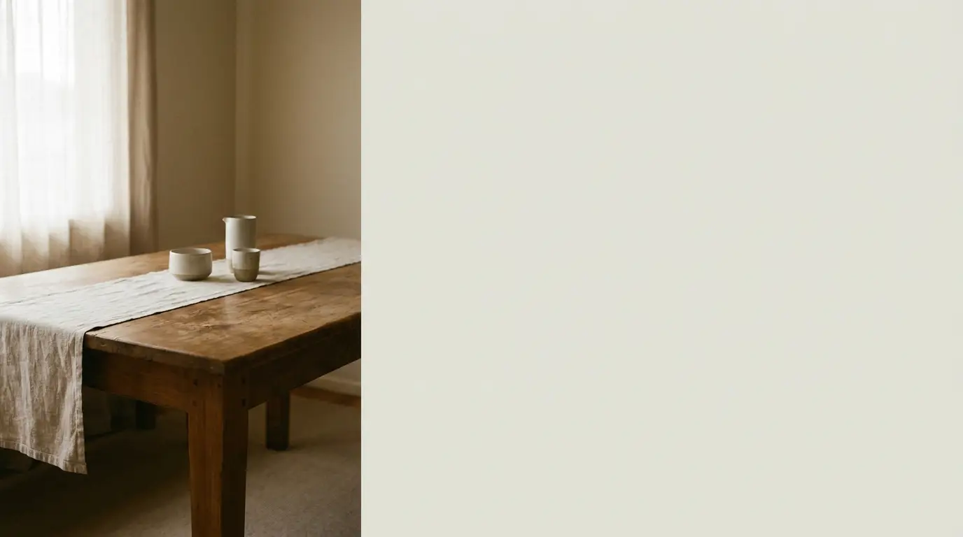 Wooden dining table with ceramic cups and linen runner in softly lit room