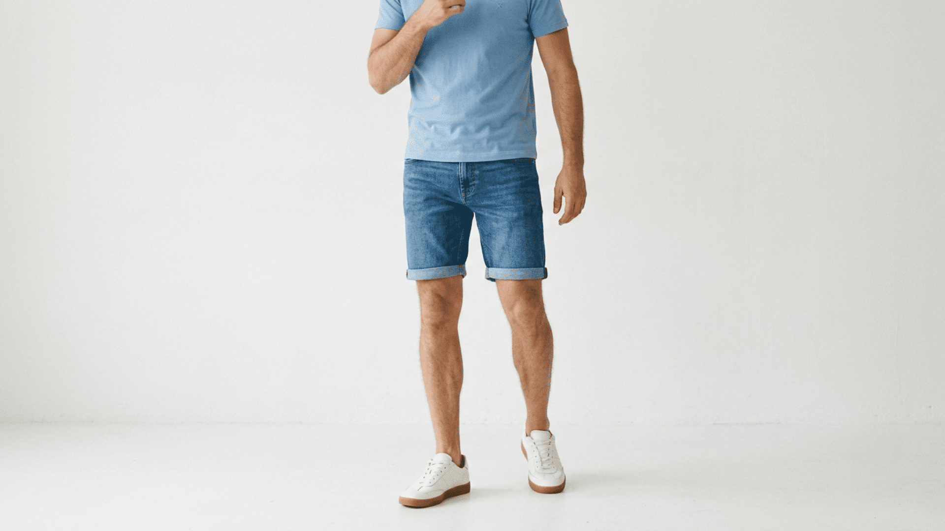 Person wearing blue denim jorts with a casual T-shirt and sneakers.