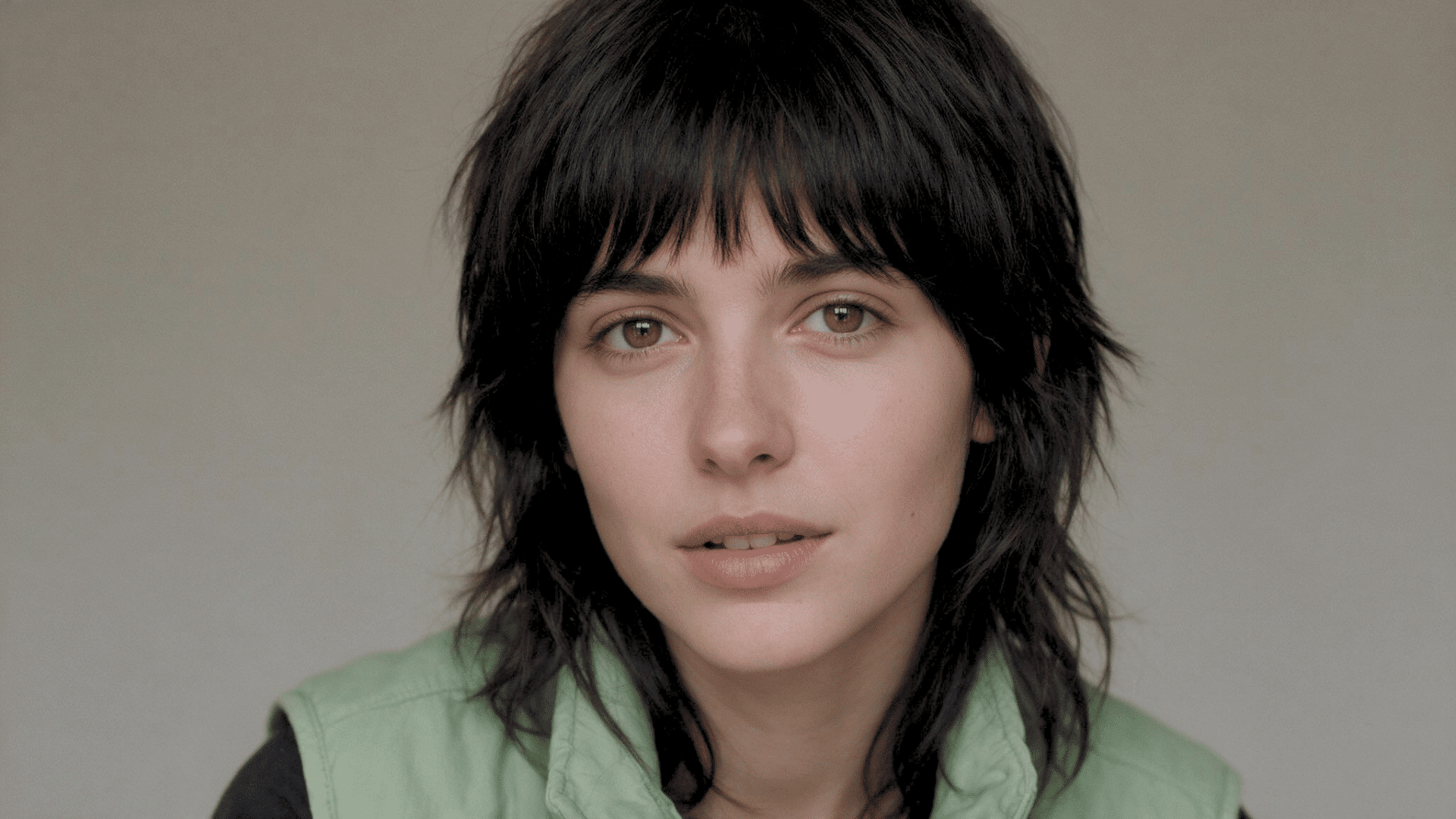 Person with a short androgynous bob hairstyle posing for a close-up portrait