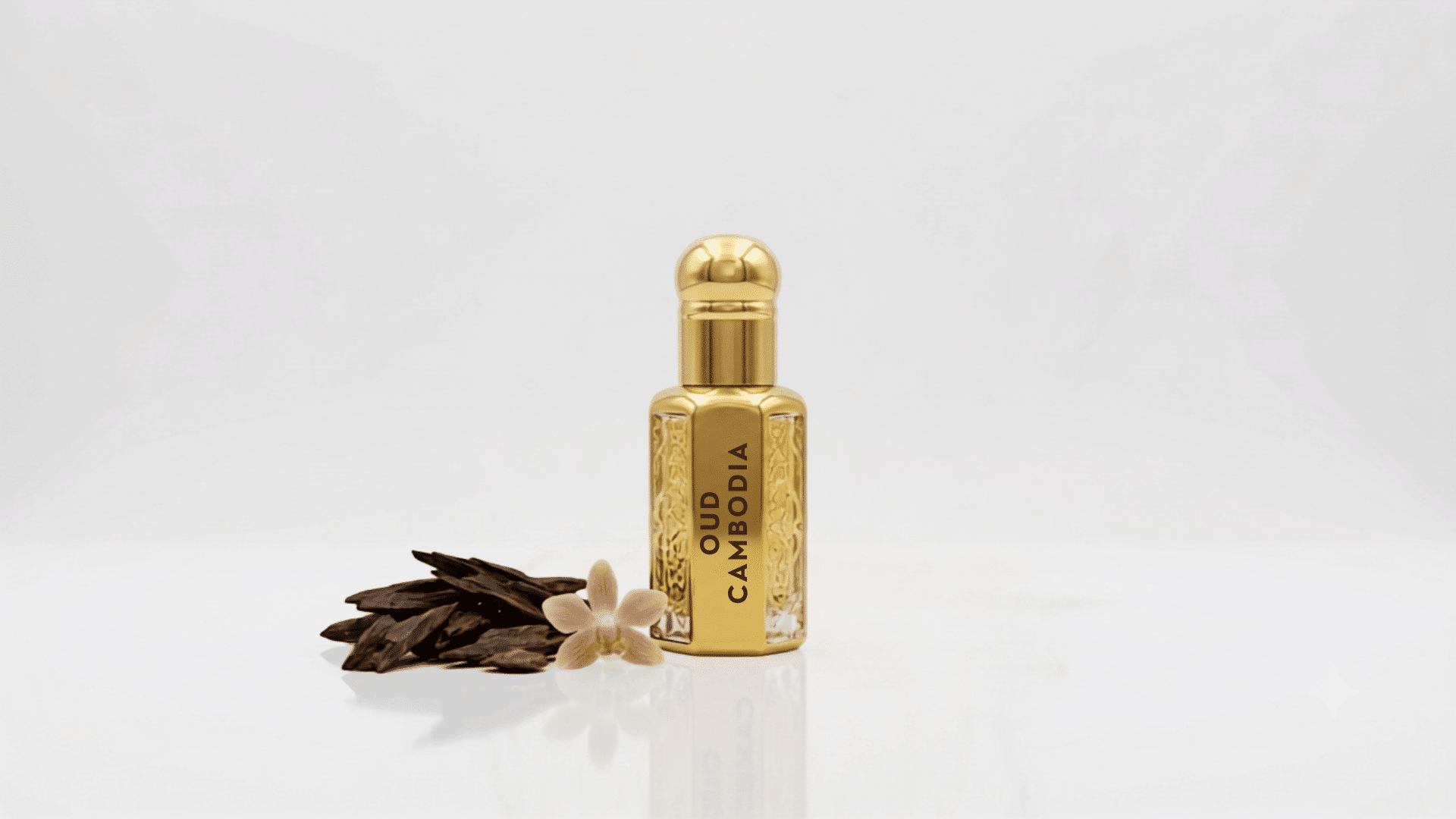 Oud Cambodia perfume bottle with agarwood pieces and a flower beside it