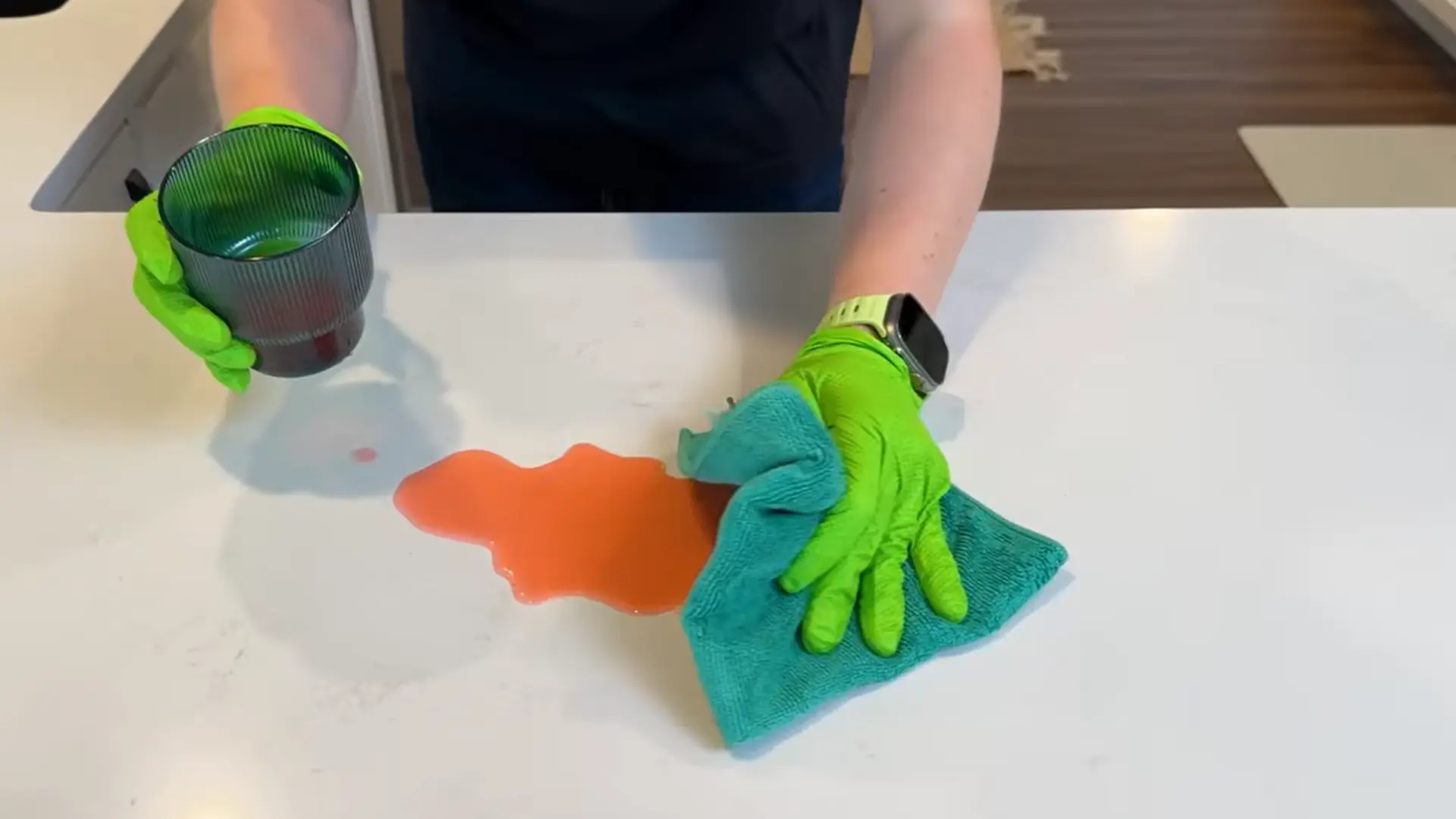 cleaning quartz countertop spill with damp cloth to prevent stains and surface damage