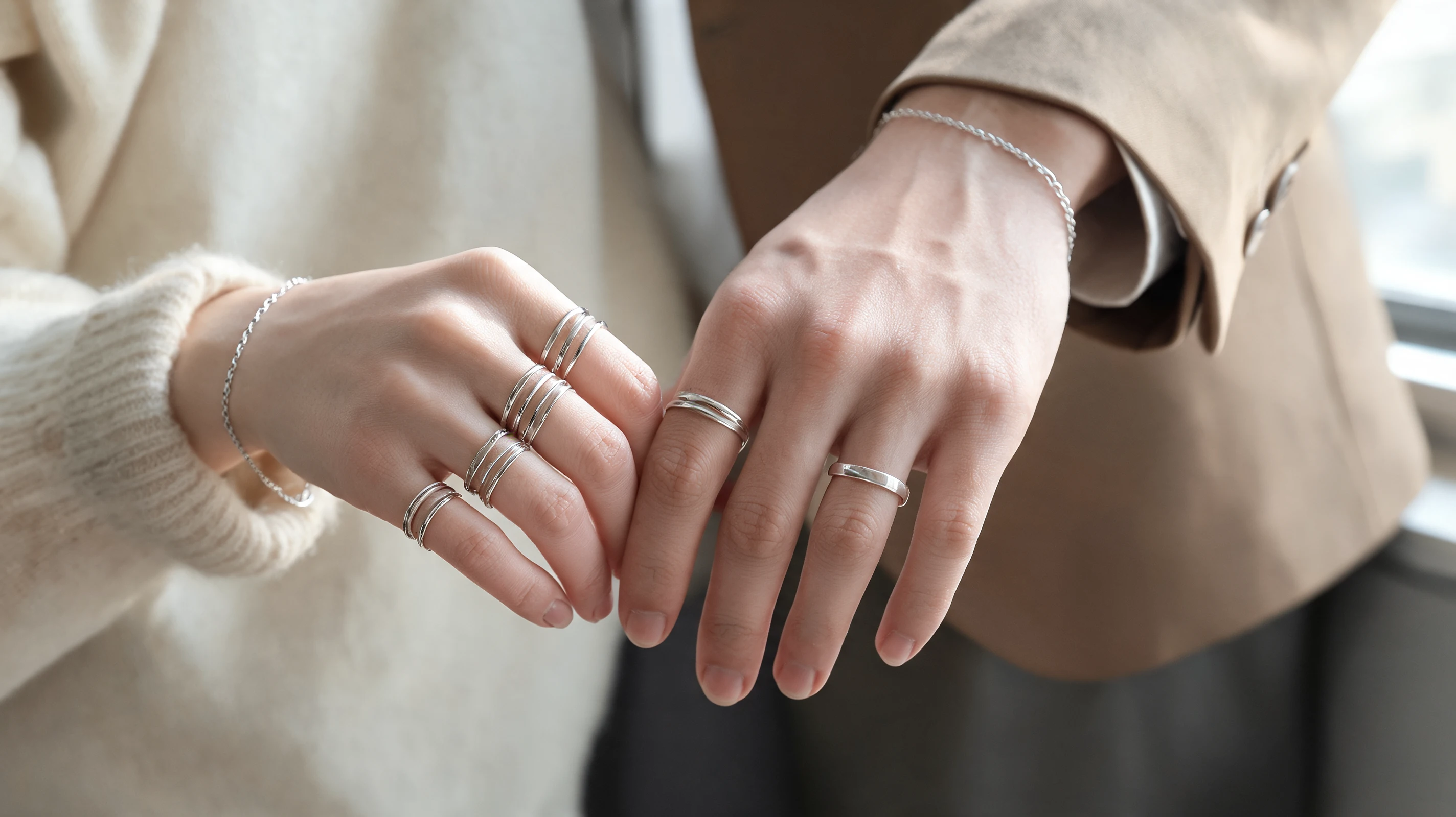 men’s and women’s hands styled with simple rings and thin stacked rings for a clean accessory detail