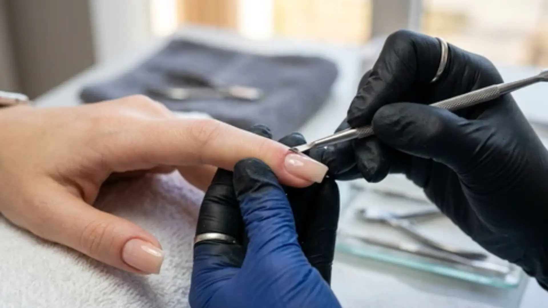 rusaian mnaicure with the cuticle remover in the technician's hand