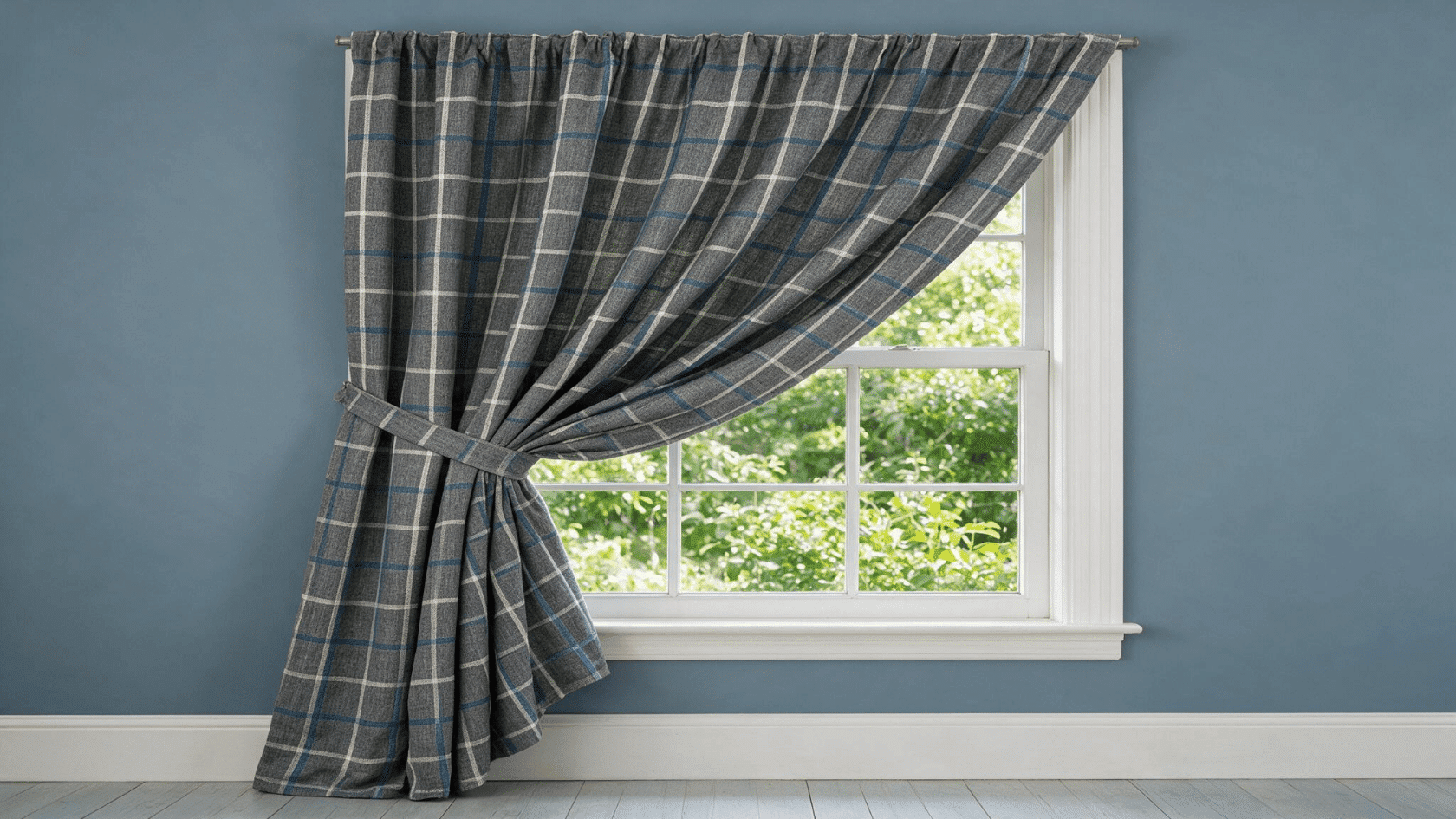 Gray checkered single panel curtains tied back beside a window in a classic room.