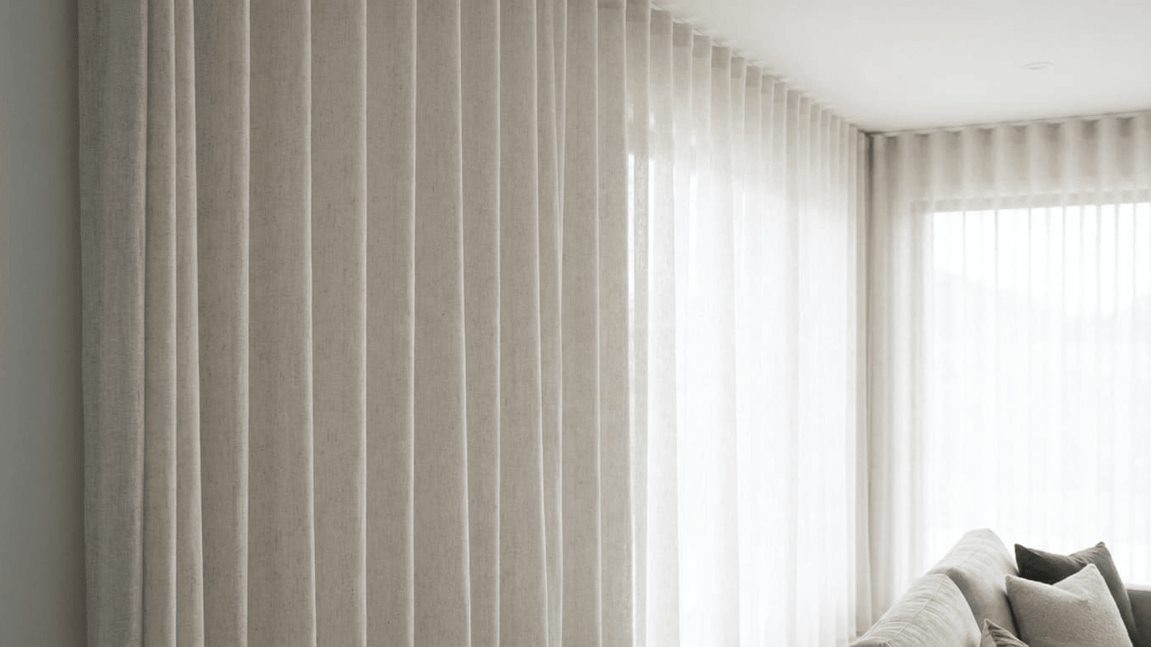 White wave fold curtains creating smooth vertical folds in a modern bright living room.