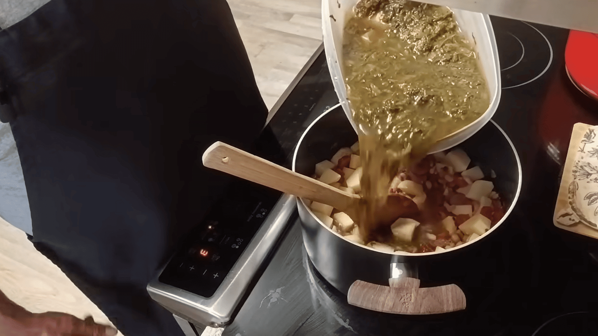 adding turnip greens and broth to sausage, beans, and potatoes for swamp soup.