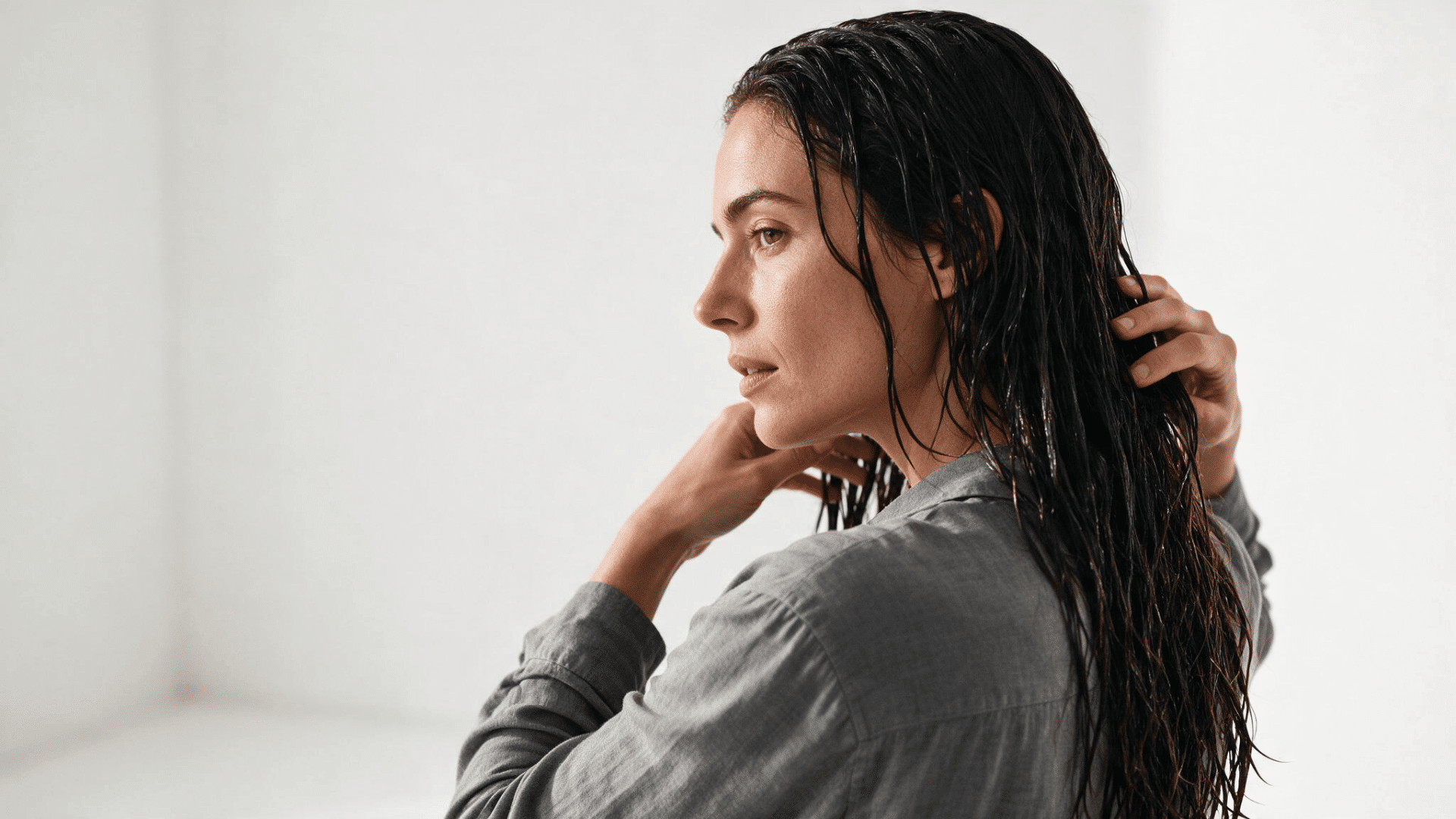 applying leave-in conditioner through wet curly hair during a curly hair wash day routine