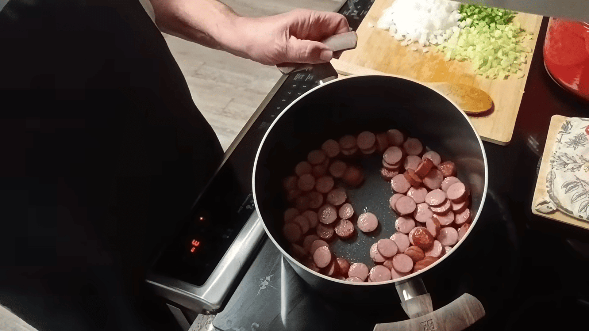 browning sliced smoked sausage in a pot for swamp soup recipe.