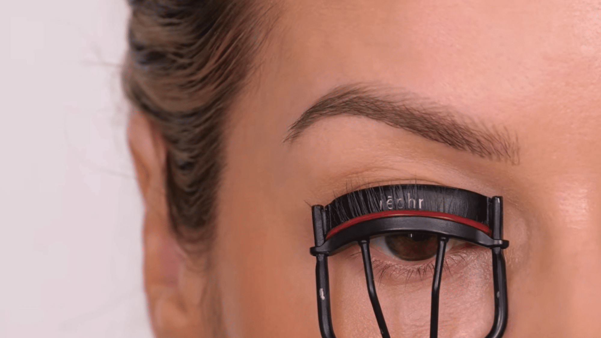 curl the eyelashes gently with an eyelash curler to lift and define them for a more open eye appearance