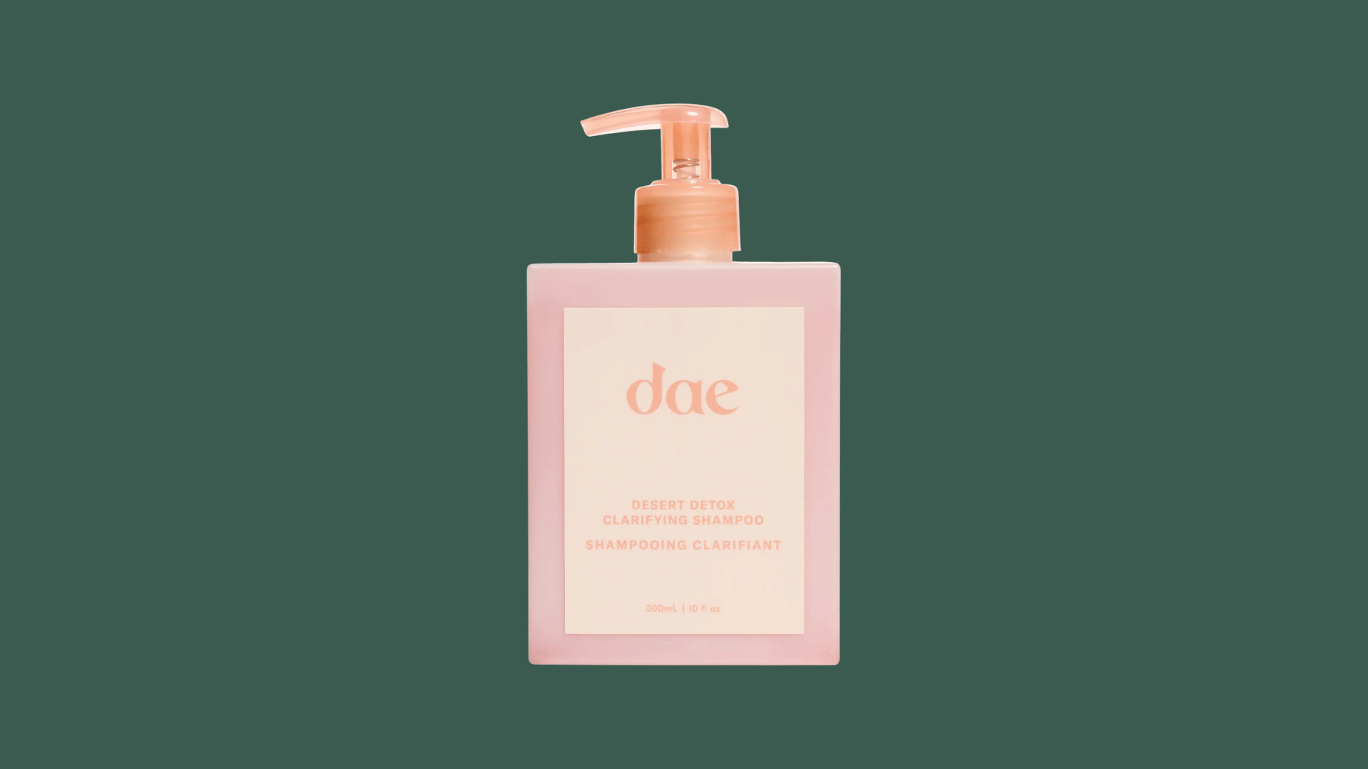 dae desert detox clarifying shampoo bottle with pink packaging on a dark green background for hair care product display