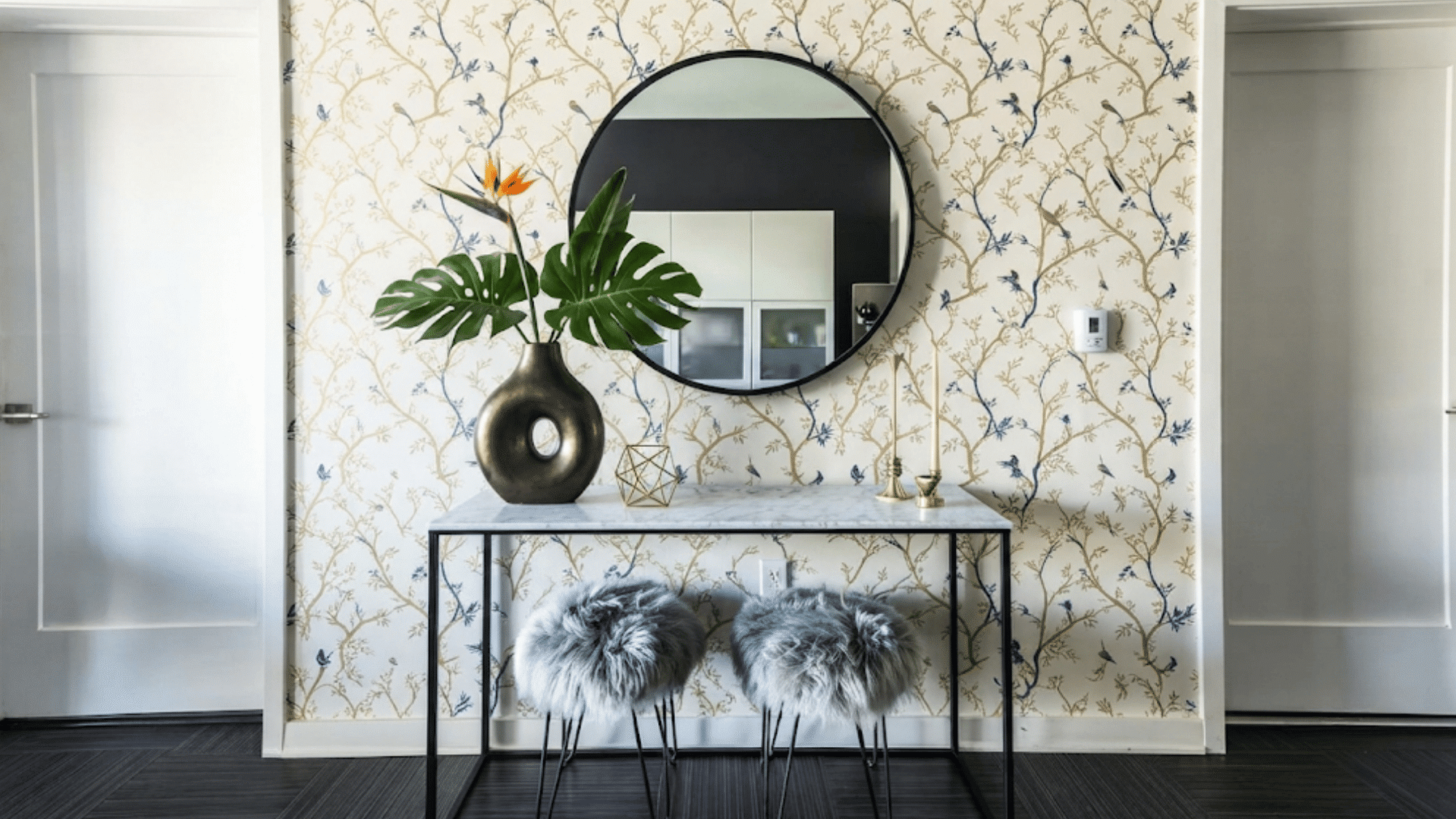 eclectic interior design with bold wallpaper creating a striking backdrop for layered furniture artwork and decor