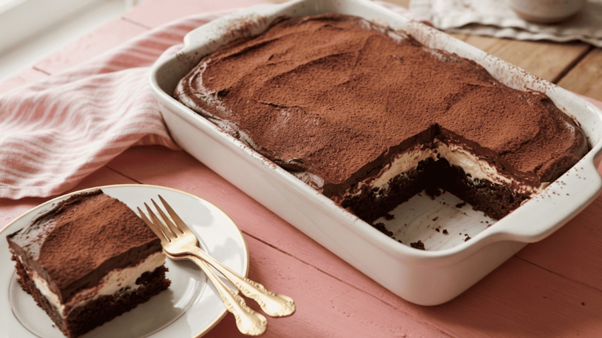 italian love cake with chocolate layers creamy filling cocoa topping and a sliced piece served on a plate