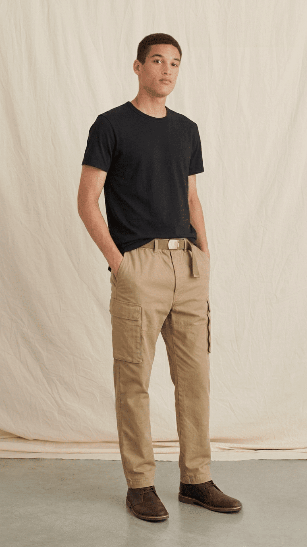 man pairing khaki cargo pants with a black t shirt and sneakers for a modern casual streetwear look