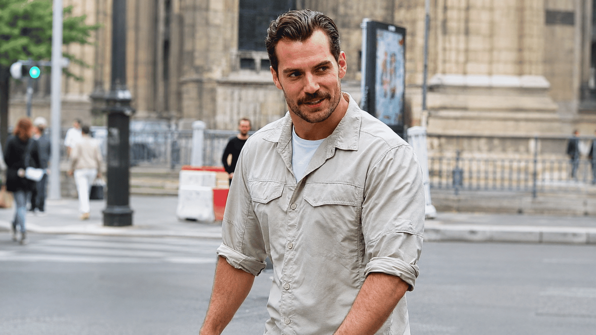 man wearing executive contour hairstyle with light stubble beige overshirt and white tee while walking on a city street