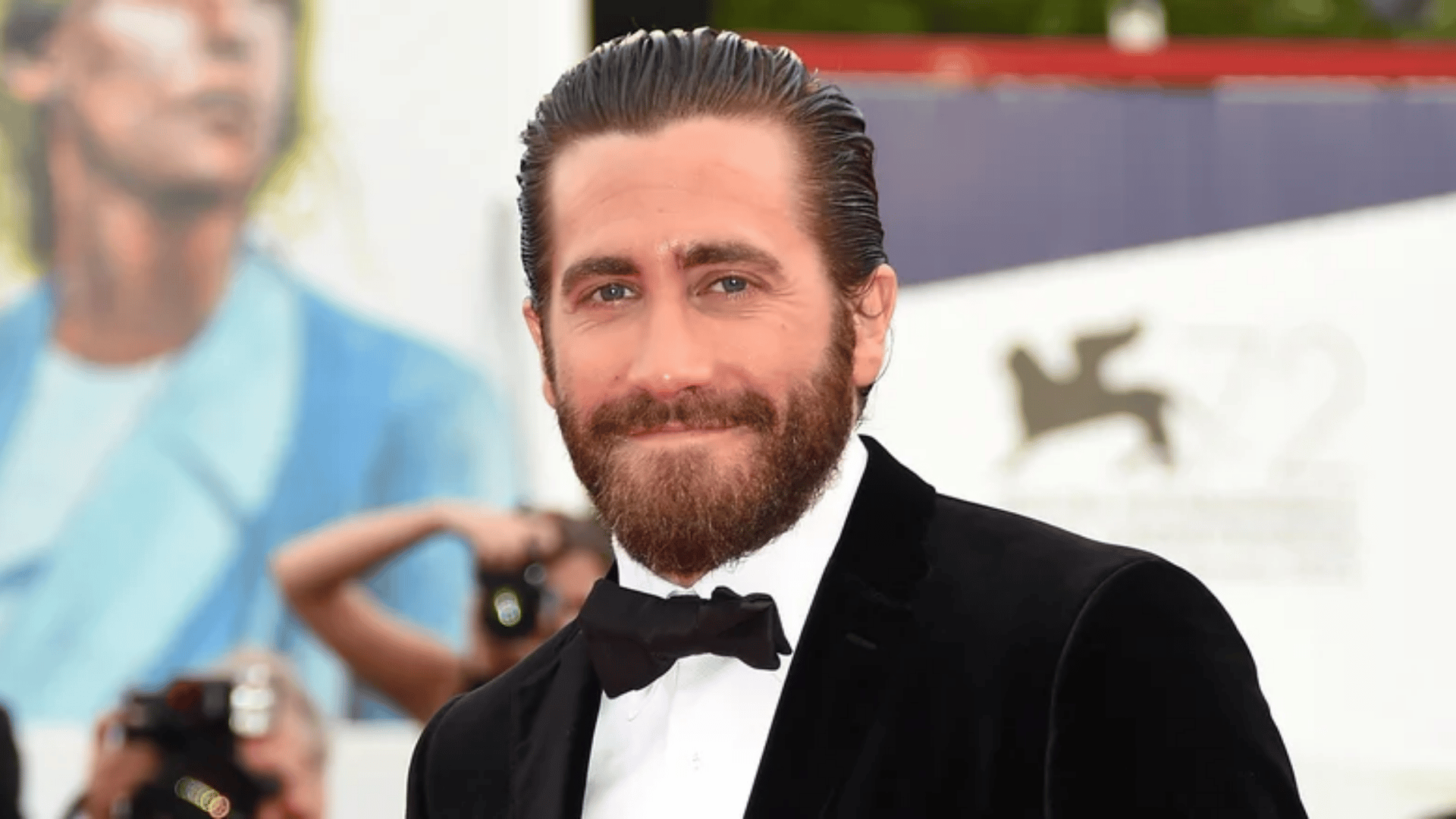 man wearing slicked back hair with full beard black tuxedo white shirt and bow tie at a formal event