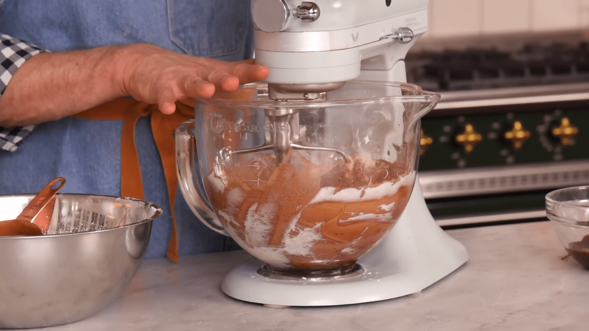 mixing hot fudge and cream into chocolate frosting for a smooth silky consistency