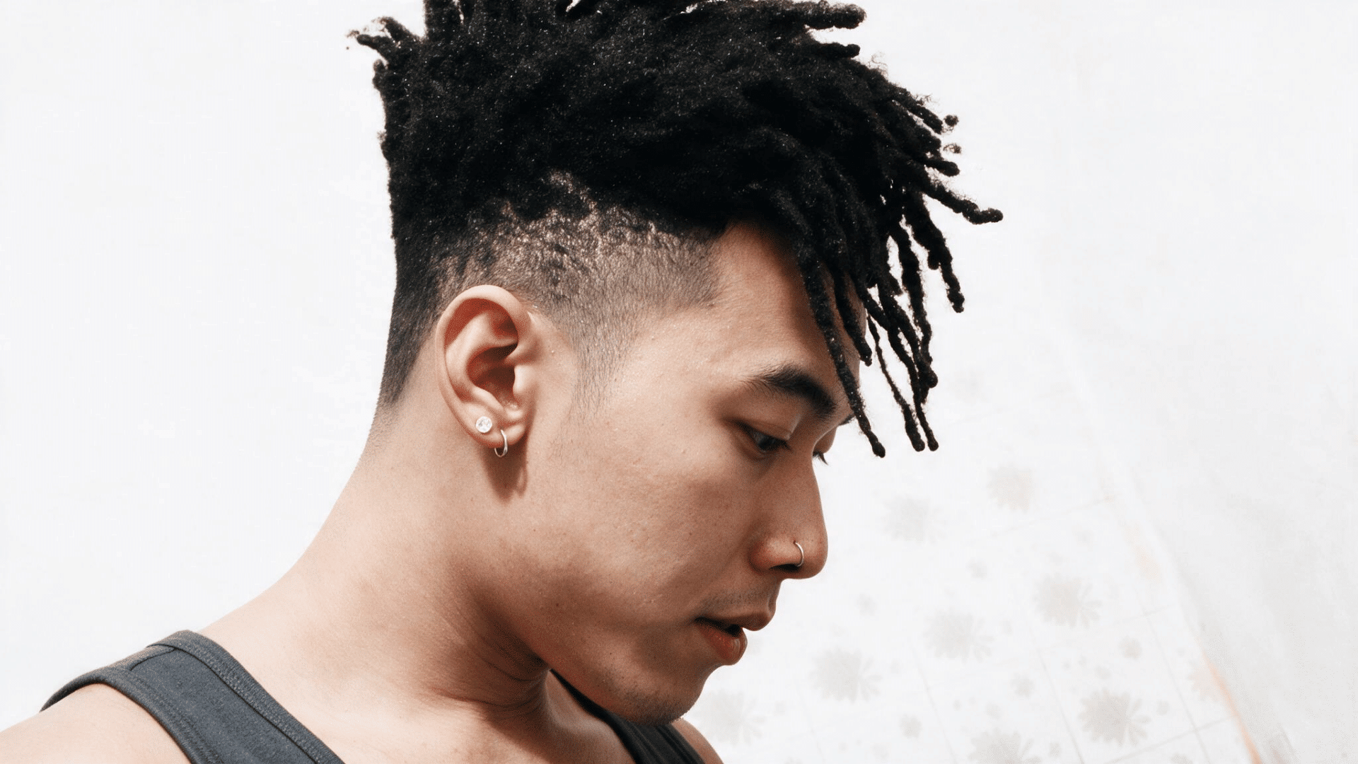 person wearing a dreadlock mohawk with long locs through the center and closely shaved hair along both sides of the head
