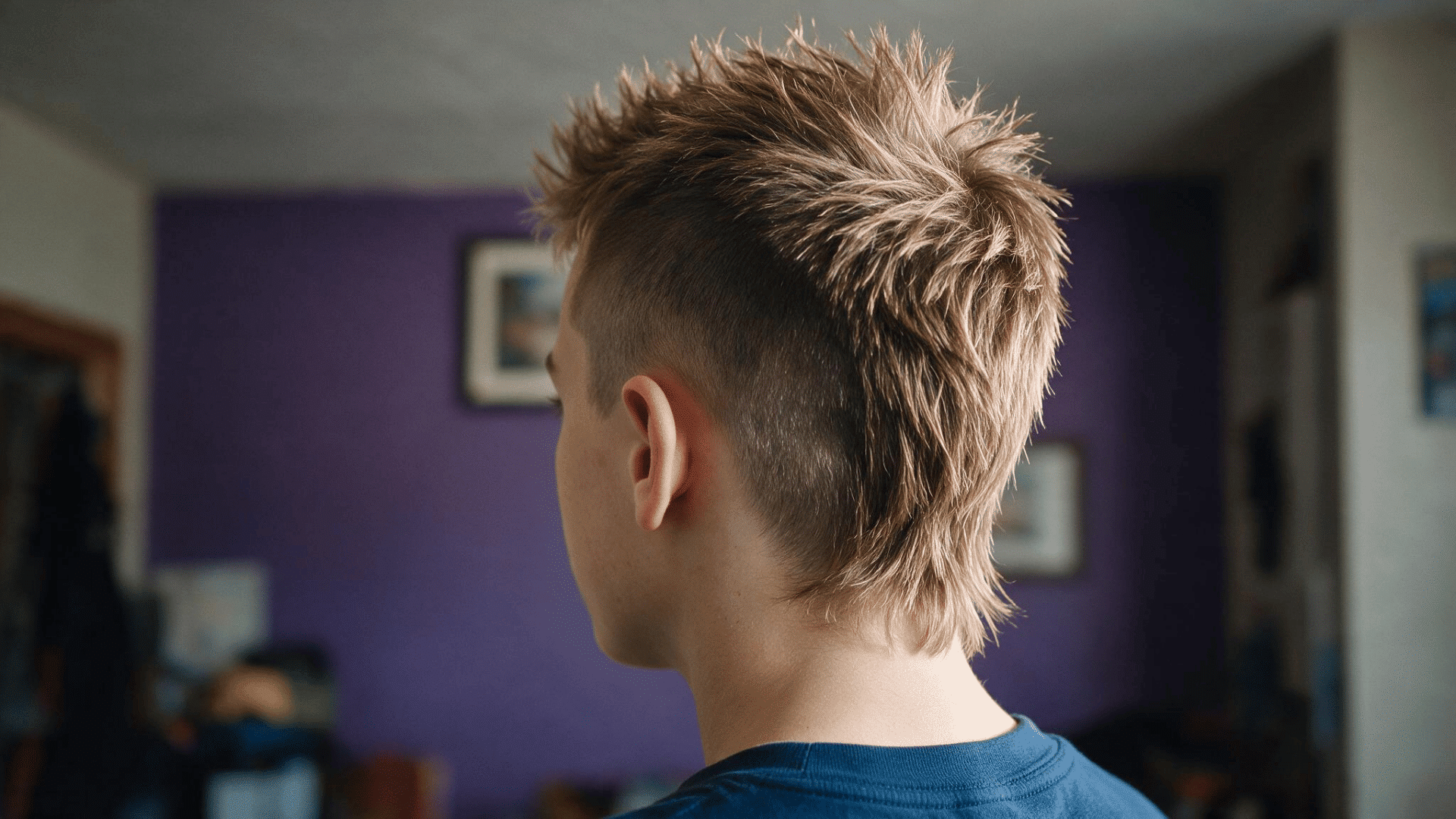 person wearing a mullet mohawk with spiked center hair short sides and longer hair extending down the back of the head
