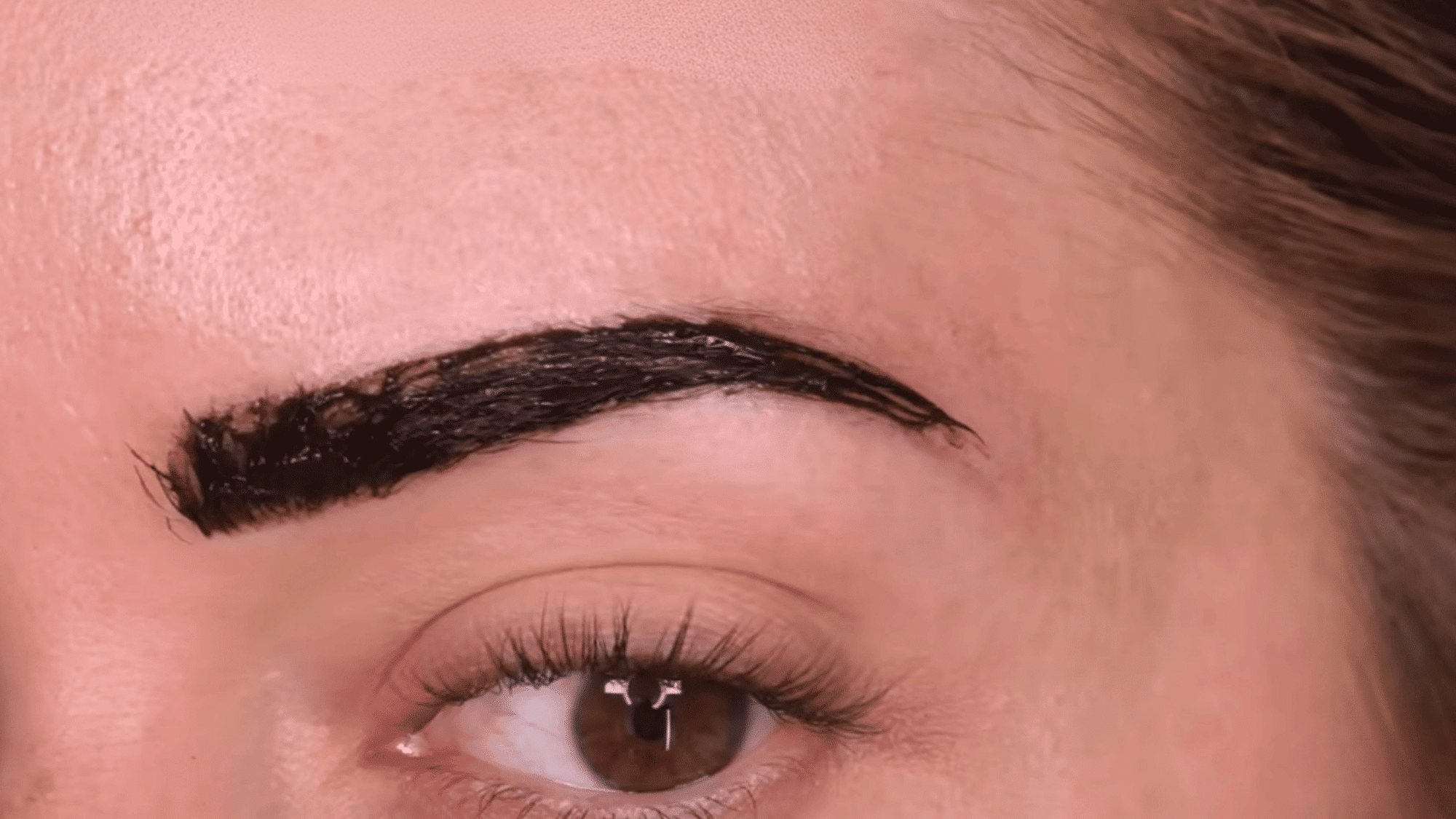 reapplying eyebrow tint carefully to achieve an even natural looking brow color without harsh lines