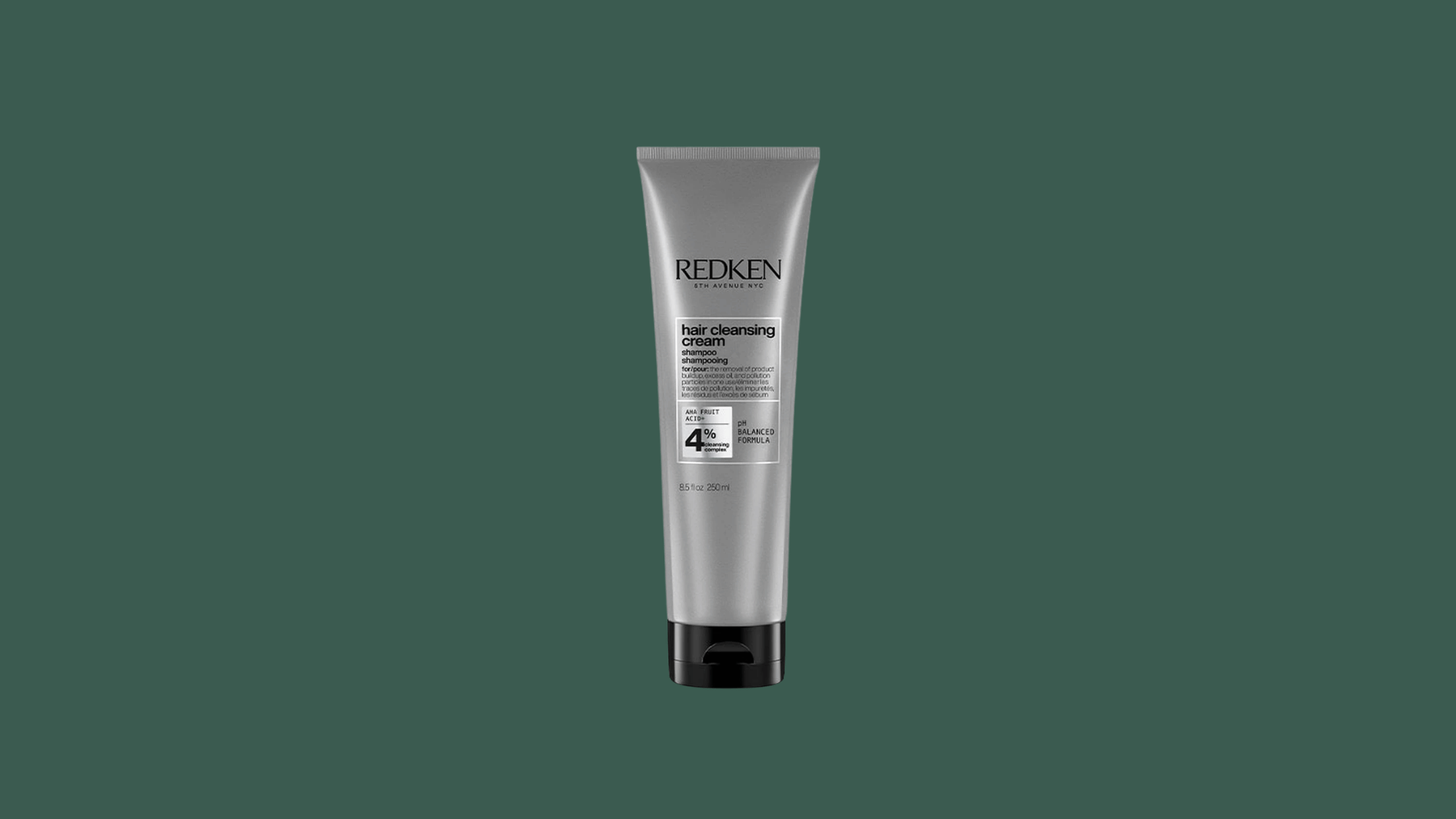 redken hair cleansing cream shampoo tube with silver packaging on a dark green background for product display