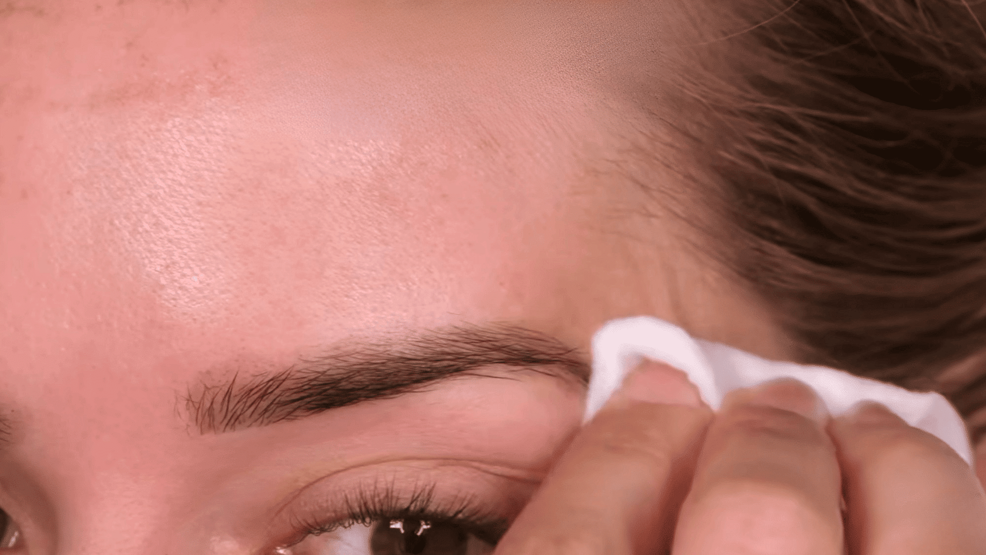 removing eyebrow tint gently with a cotton pad and cleansing solution for a clean natural finish