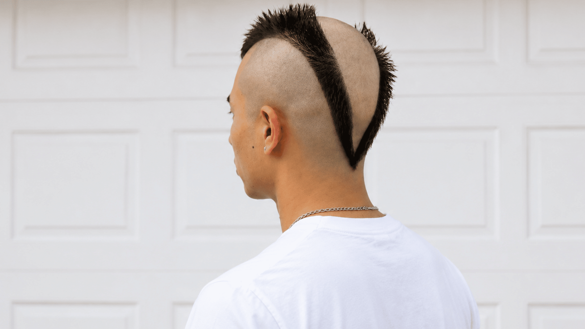 reverse mohawk with a shaved center strip and long dark spiked hair along both sides