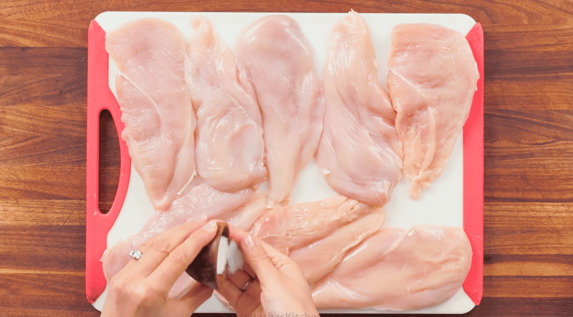 seasoning evenly pounded chicken cutlets with salt and pepper before breading.
