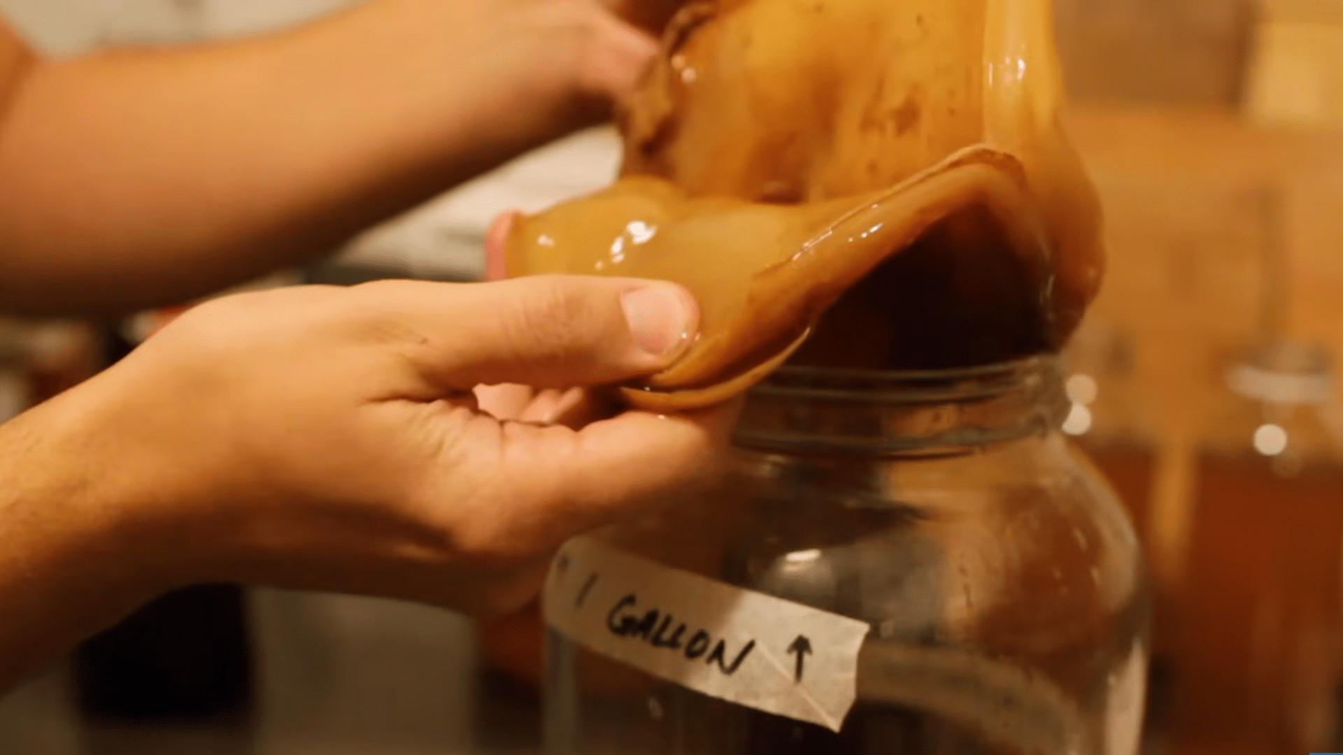tasting fermented kombucha and checking its tartness to decide when the first fermentation is ready