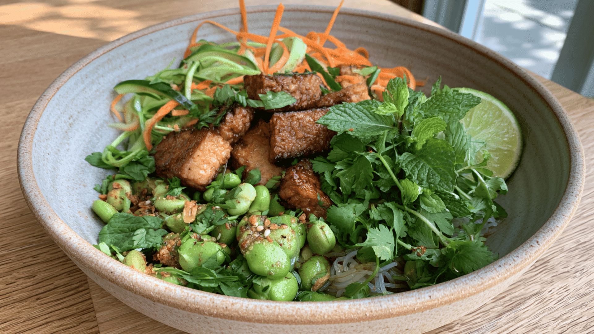 tempeh vermicelli noodle bowl with edamame cucumber carrots herbs and fresh lime dressing