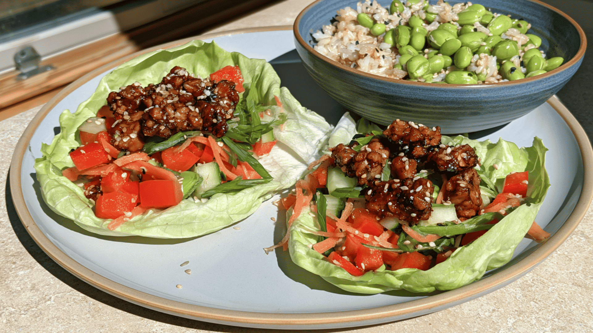 teriyaki tempeh lettuce wraps with crisp vegetables and a side bowl of edamame rice