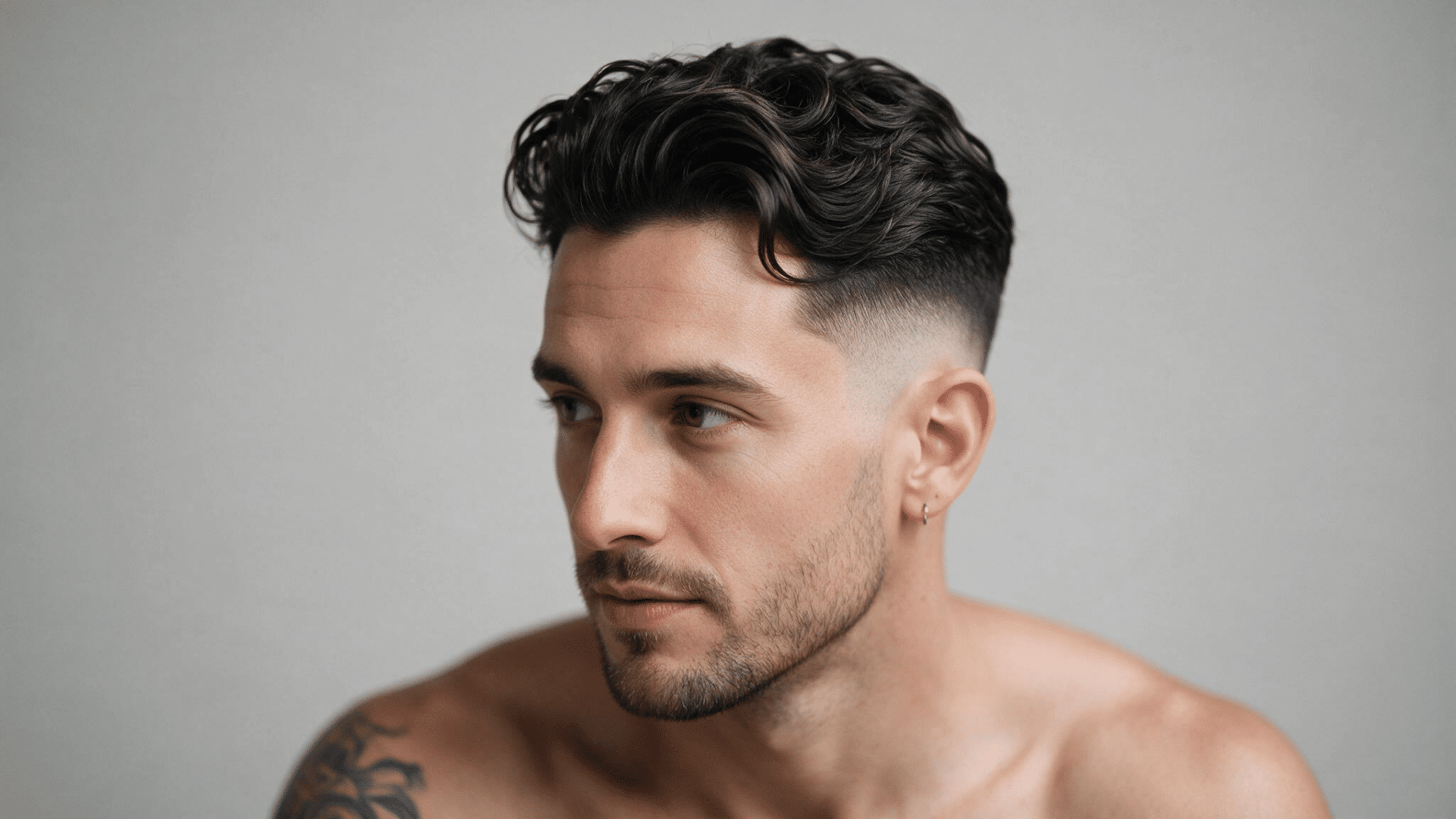 undercut hairstyle with longer swept hair on top and closely trimmed sides creating a sharp modern haircut for men