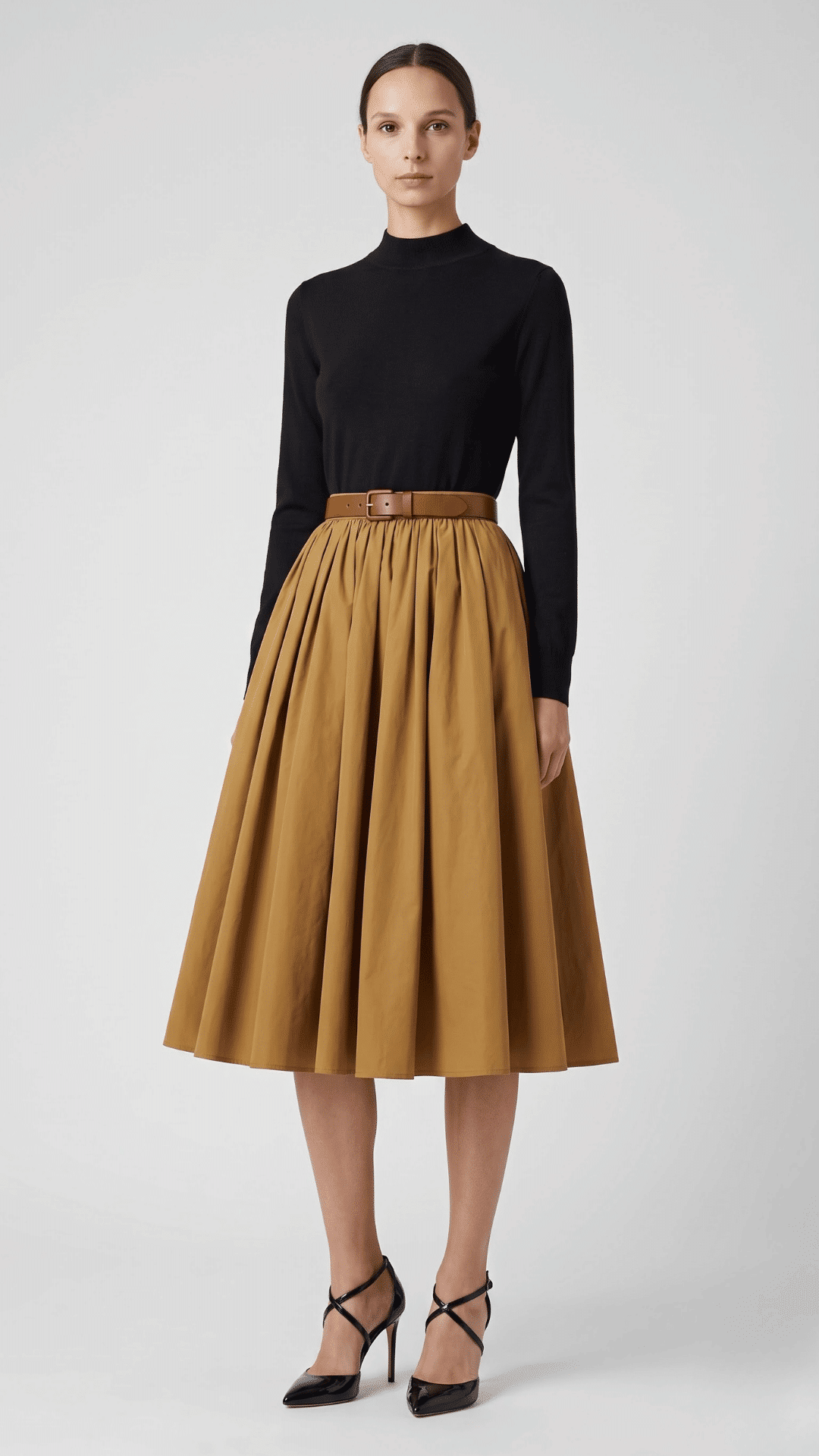 woman styling a khaki skirt with a black top and ankle boots for a simple modern casual look