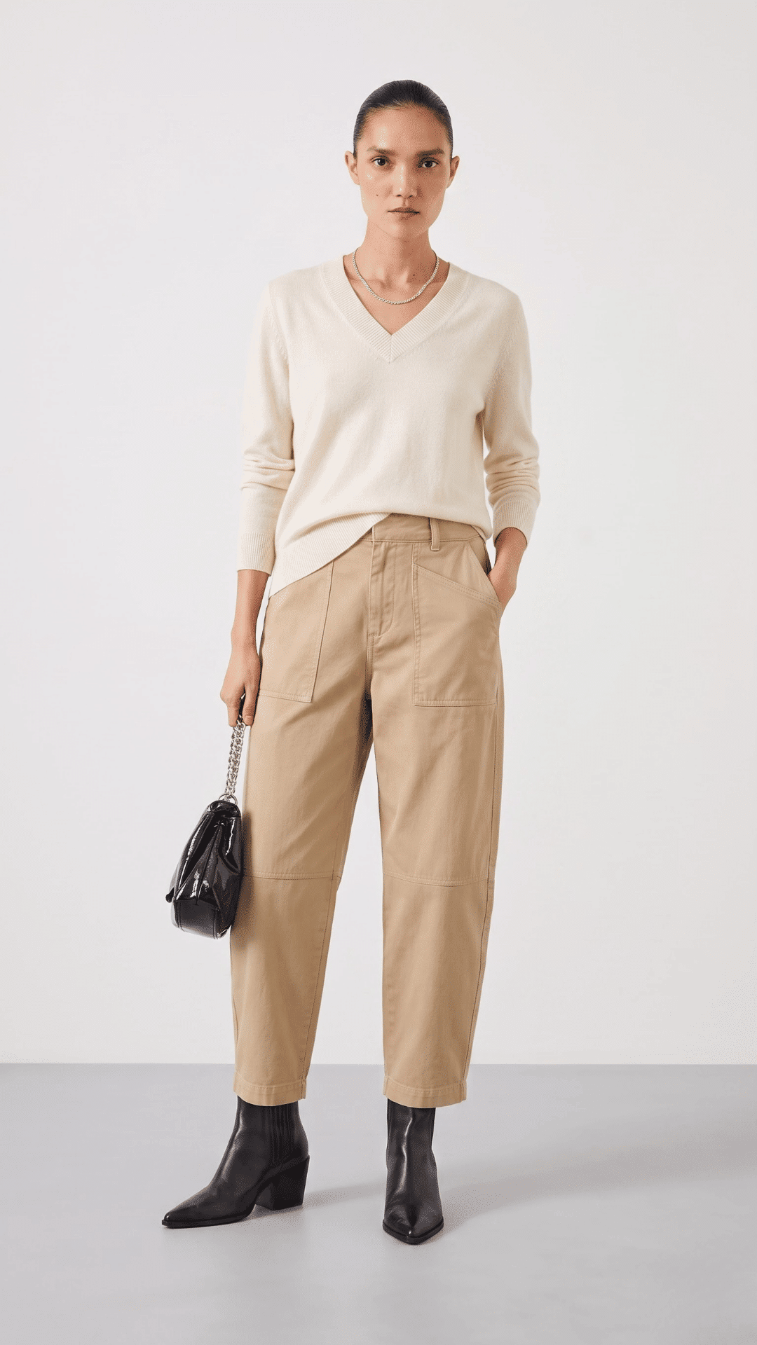 woman wearing khaki cargo pants with a cream top and white sneakers for an effortless casual outfit