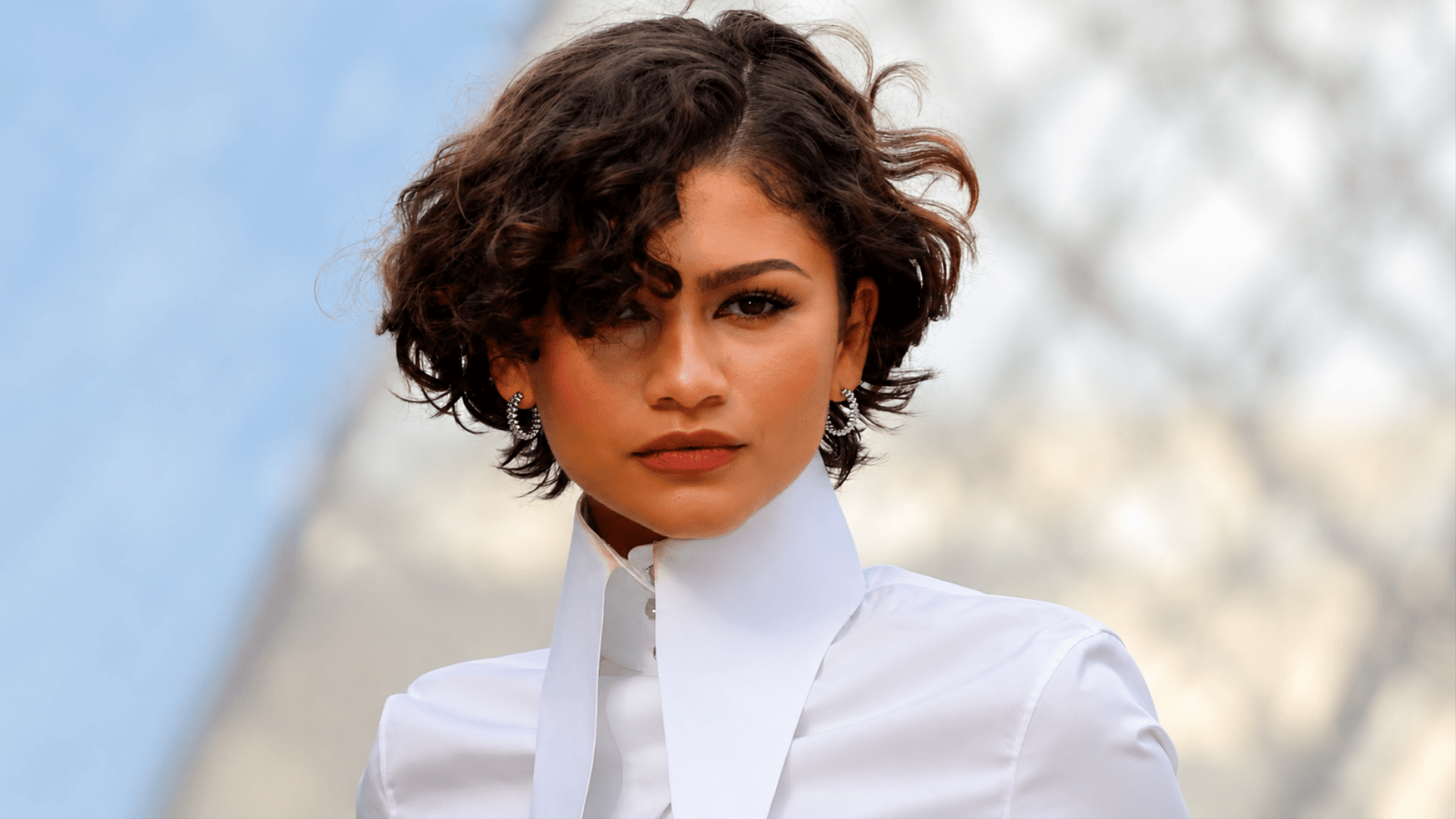 woman with layered bob cut hairstyle wearing a white high collar blouse