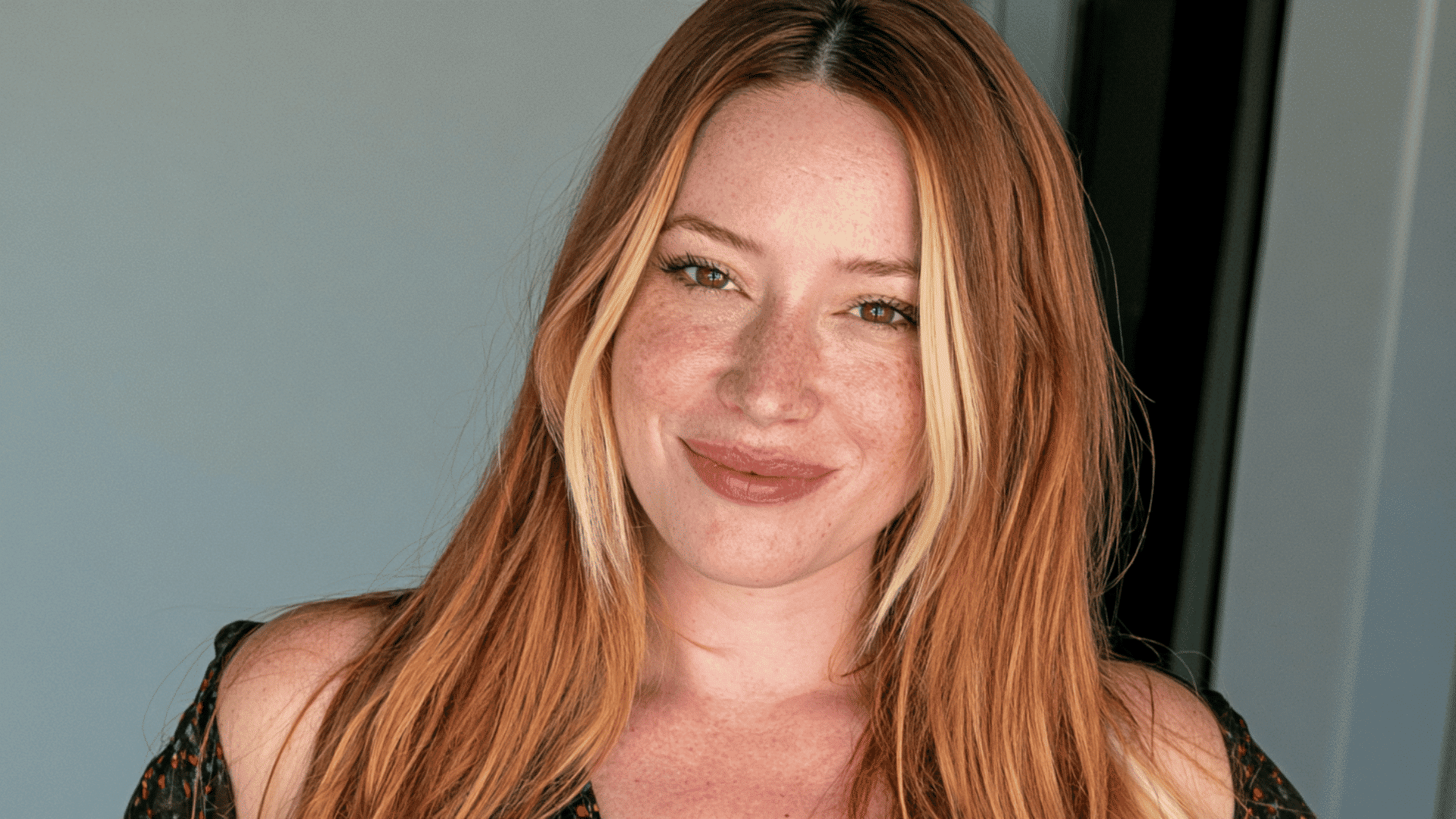 woman with long auburn hair featuring golden copper highlights and blonde face framing strands