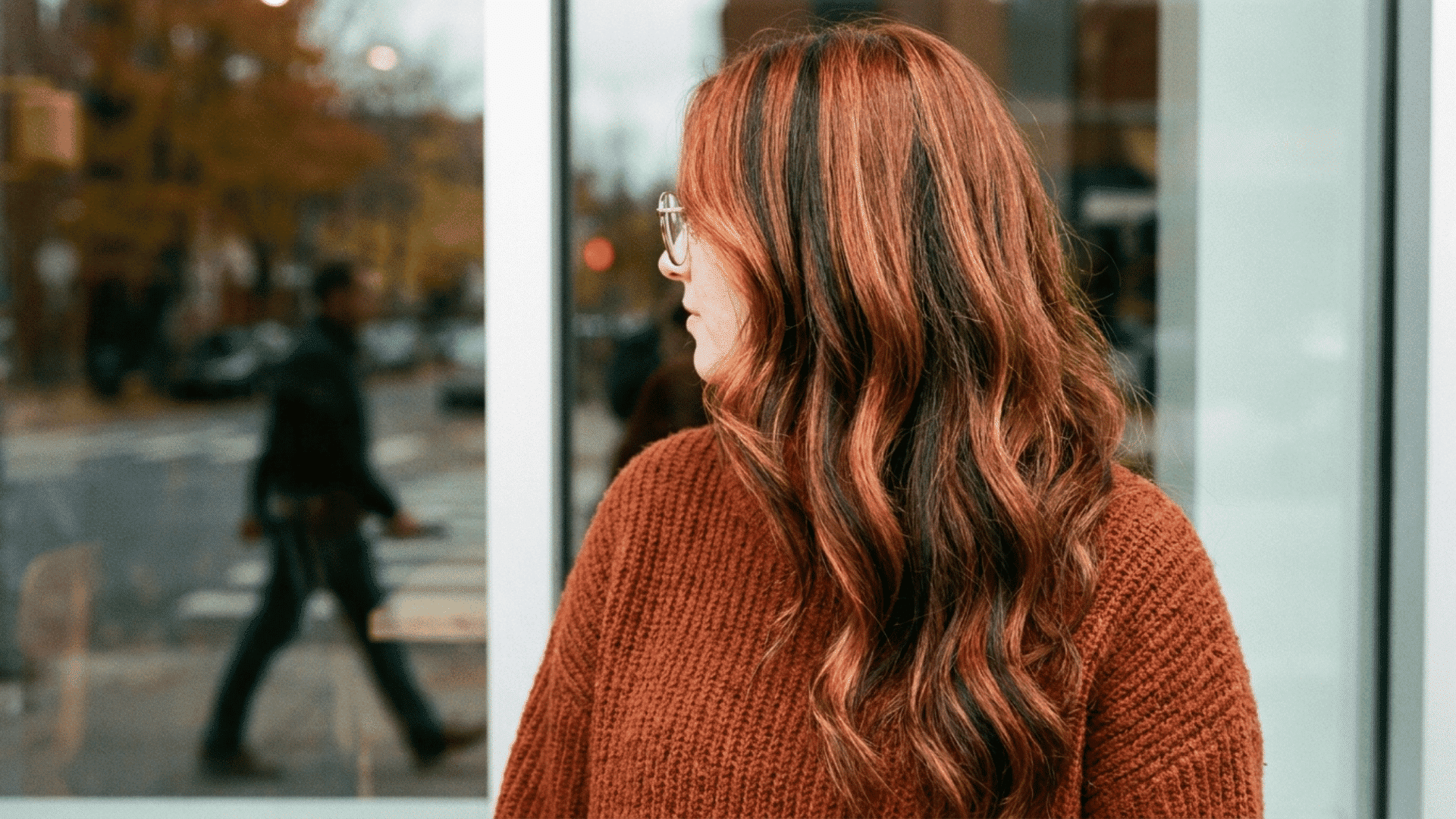 Woman with long auburn hair featuring Red chunky highlights and dark lowlights.