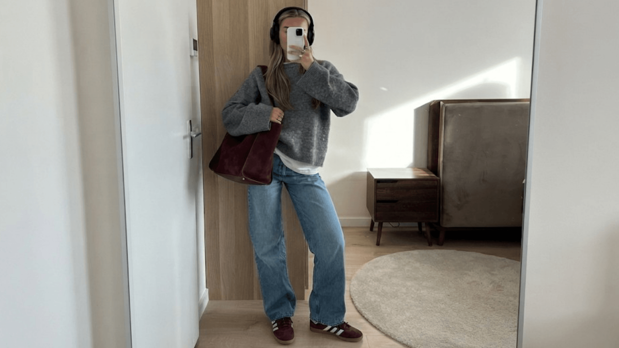 women wearing a grey sweater with burgundy shoes and blue jeans