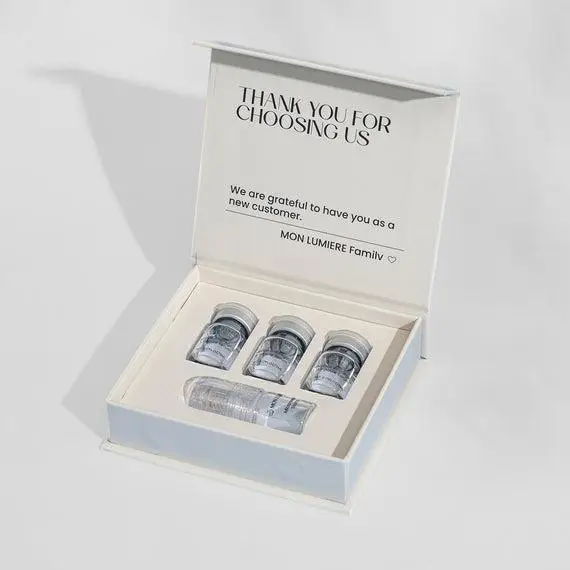 Gift box containing four skincare bottles in white packaging on a light background