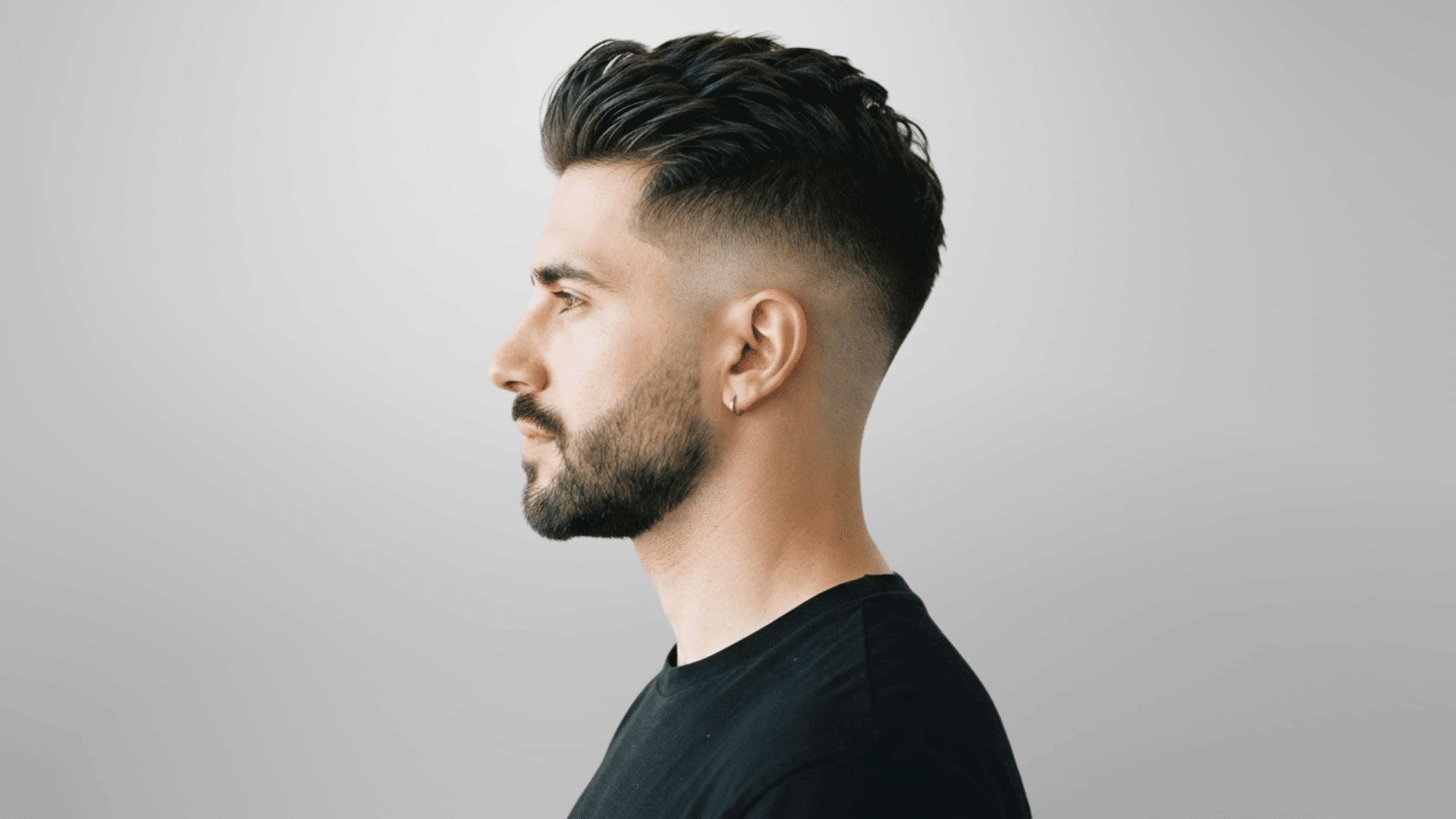 man with thinning hair wearing a brushed-up hairstyle with short sides and natural volume at the front