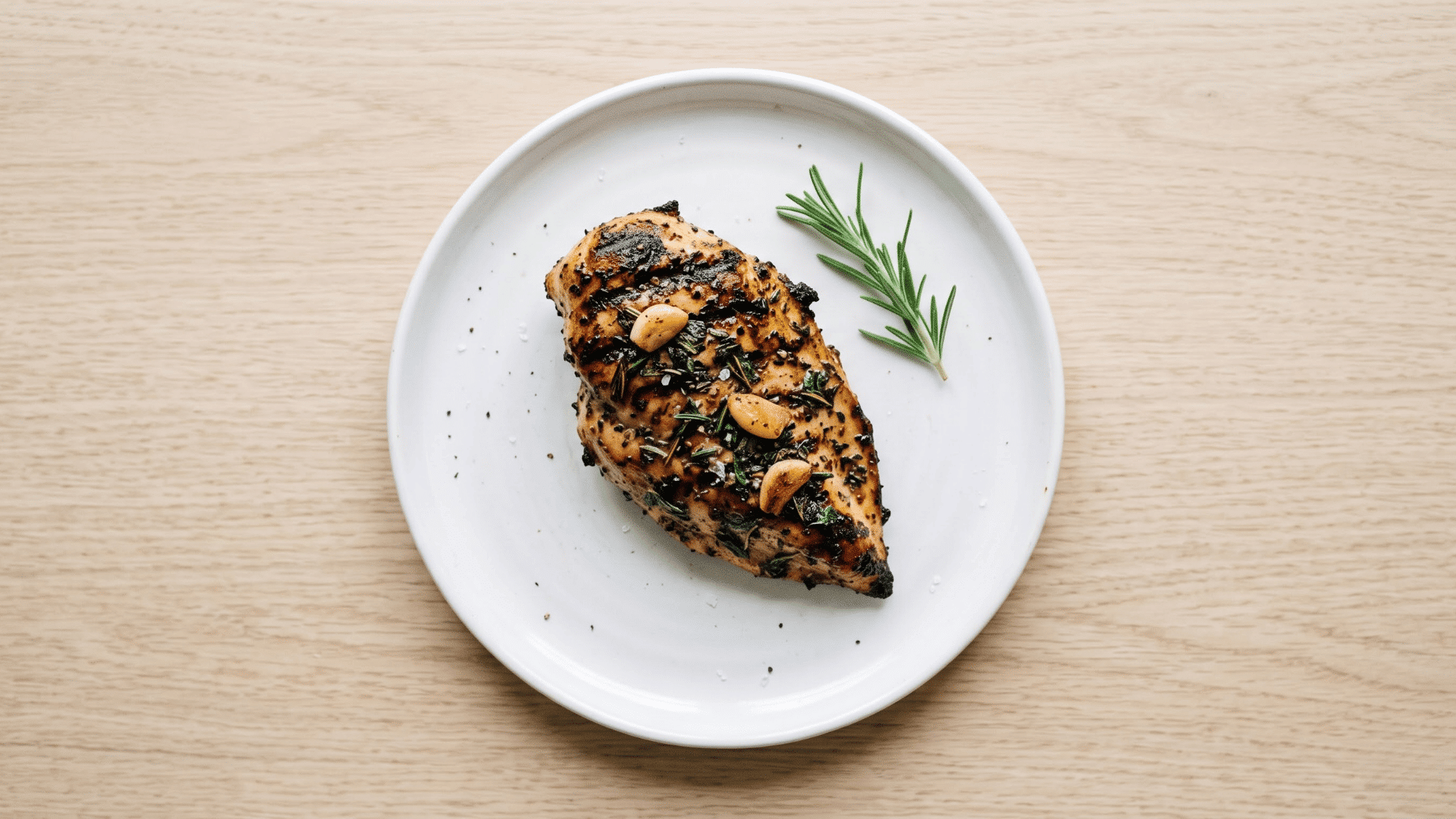 classic garlic and herb grilled chicken breast with a golden finish and fresh herbs served on a plate