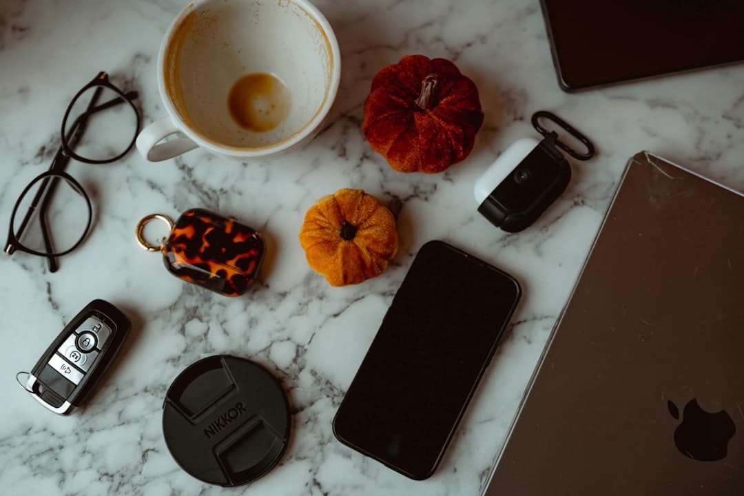 Assorted desk items including coffee cup, glasses, phone, and small pumpkins on marble surface