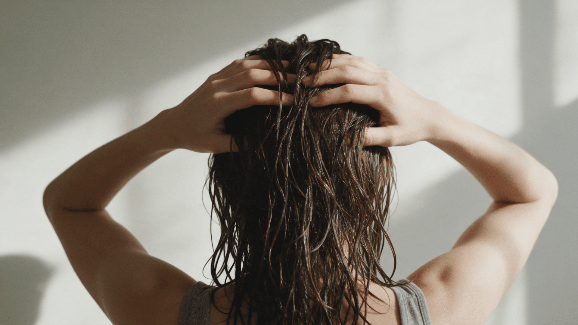 woman holding her greasy and oily hair at the scalp with visible oily strands