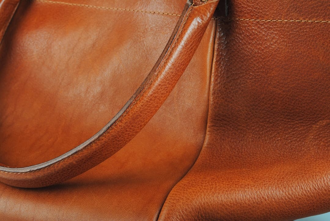 Close-up of brown leather handbag with visible stitching and textured finish