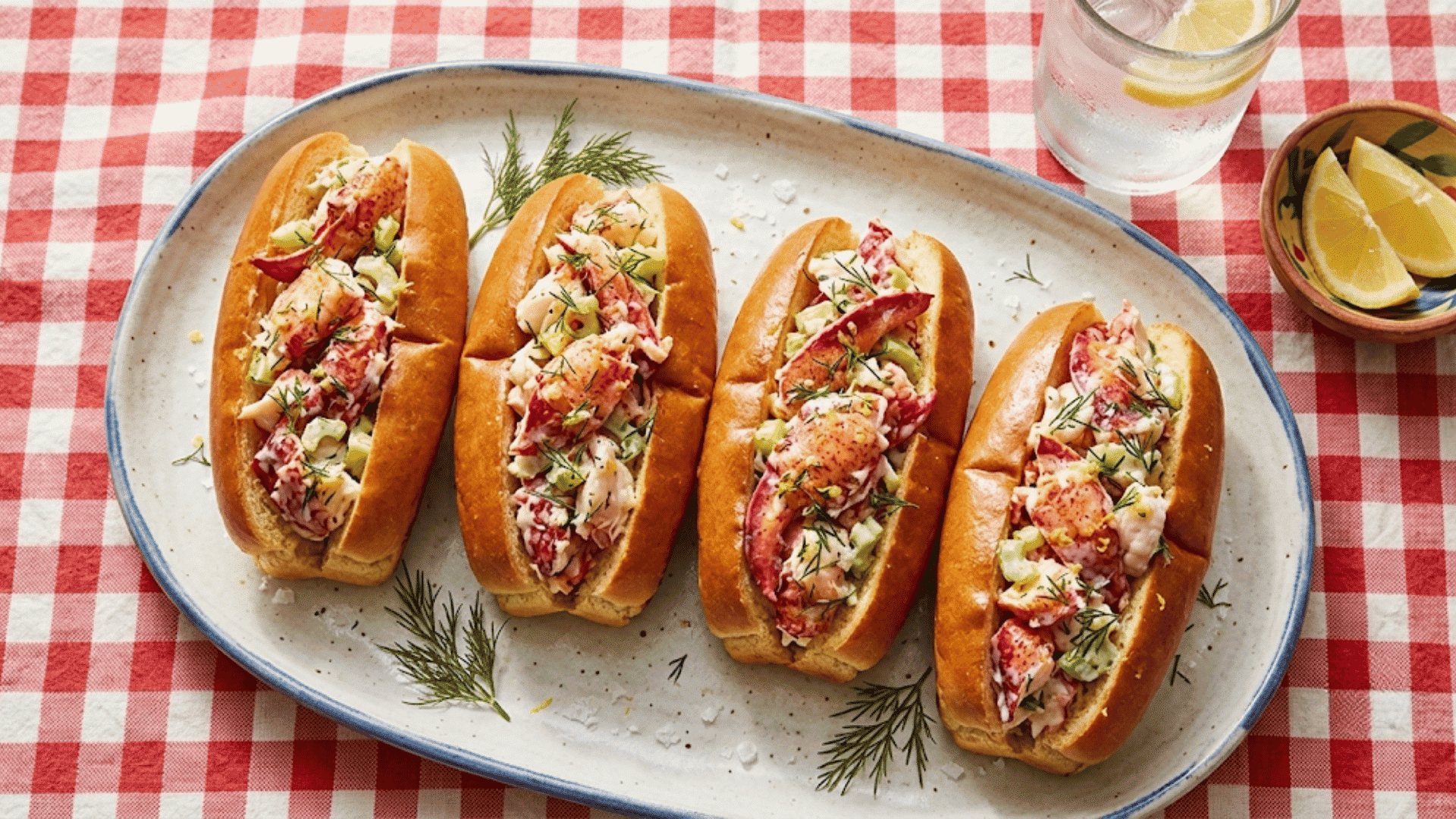 maine lobster rolls filled with creamy lobster meat and celery served with fresh lemon wedges and dill