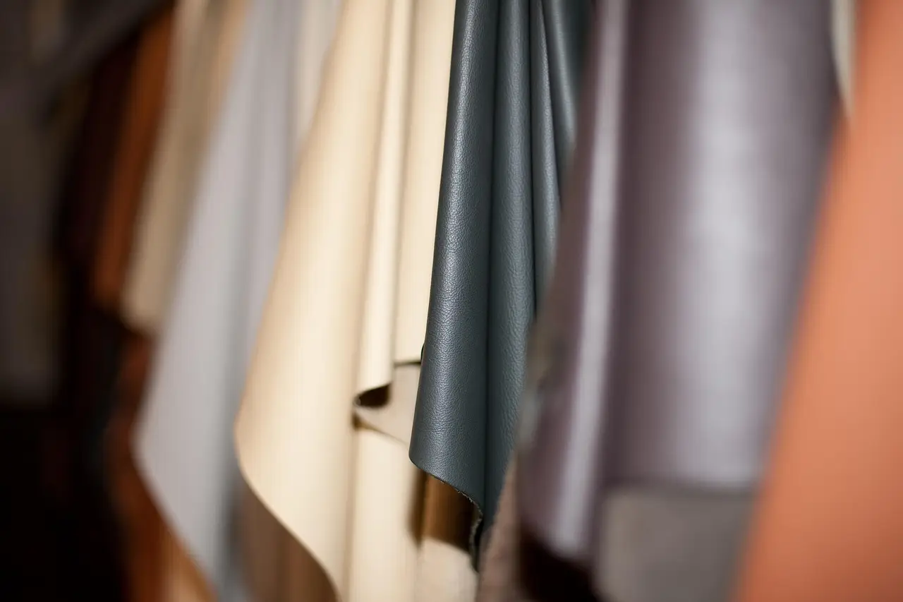 Close-up of various colored leather fabrics hanging indoors