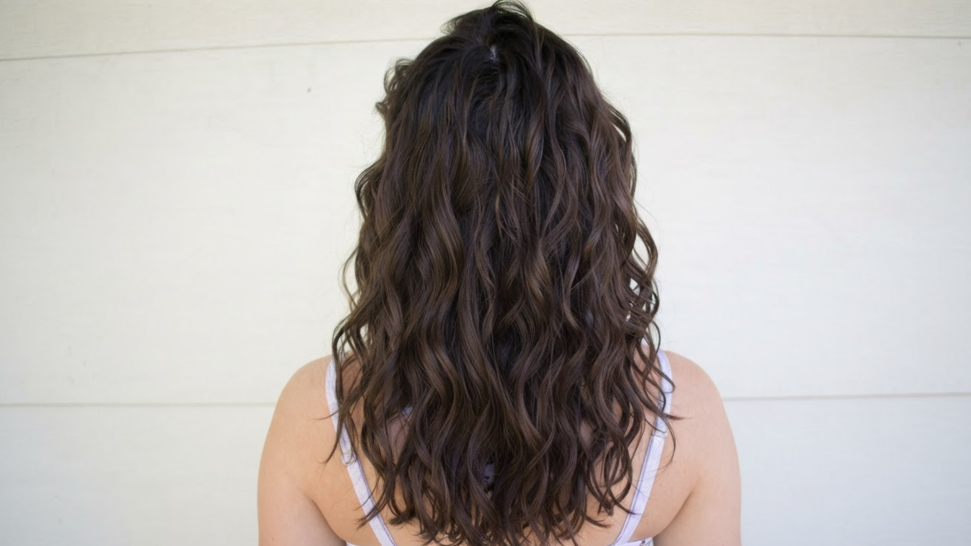 back view of shoulder length dark brown wavy hair with soft loose curls and natural volume