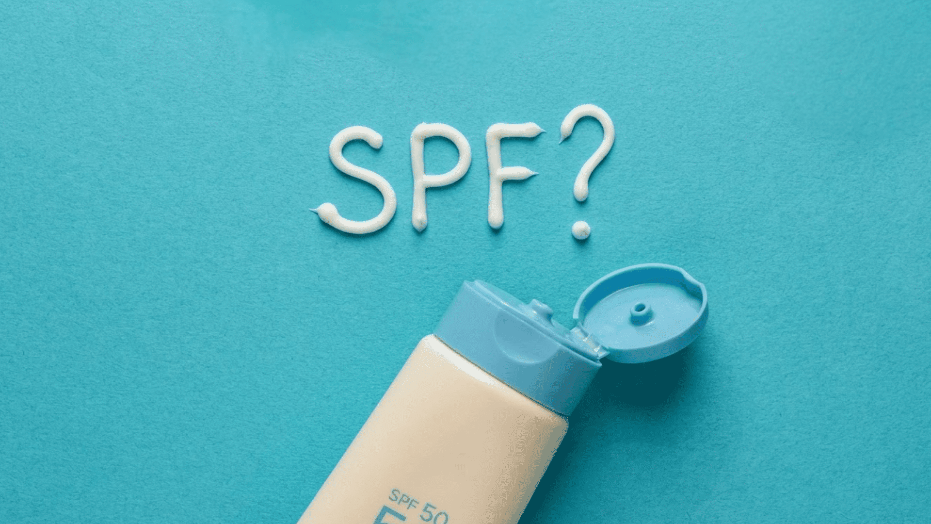 sunscreen bottle with spf cream arranged on a blue background to represent daily sun protection